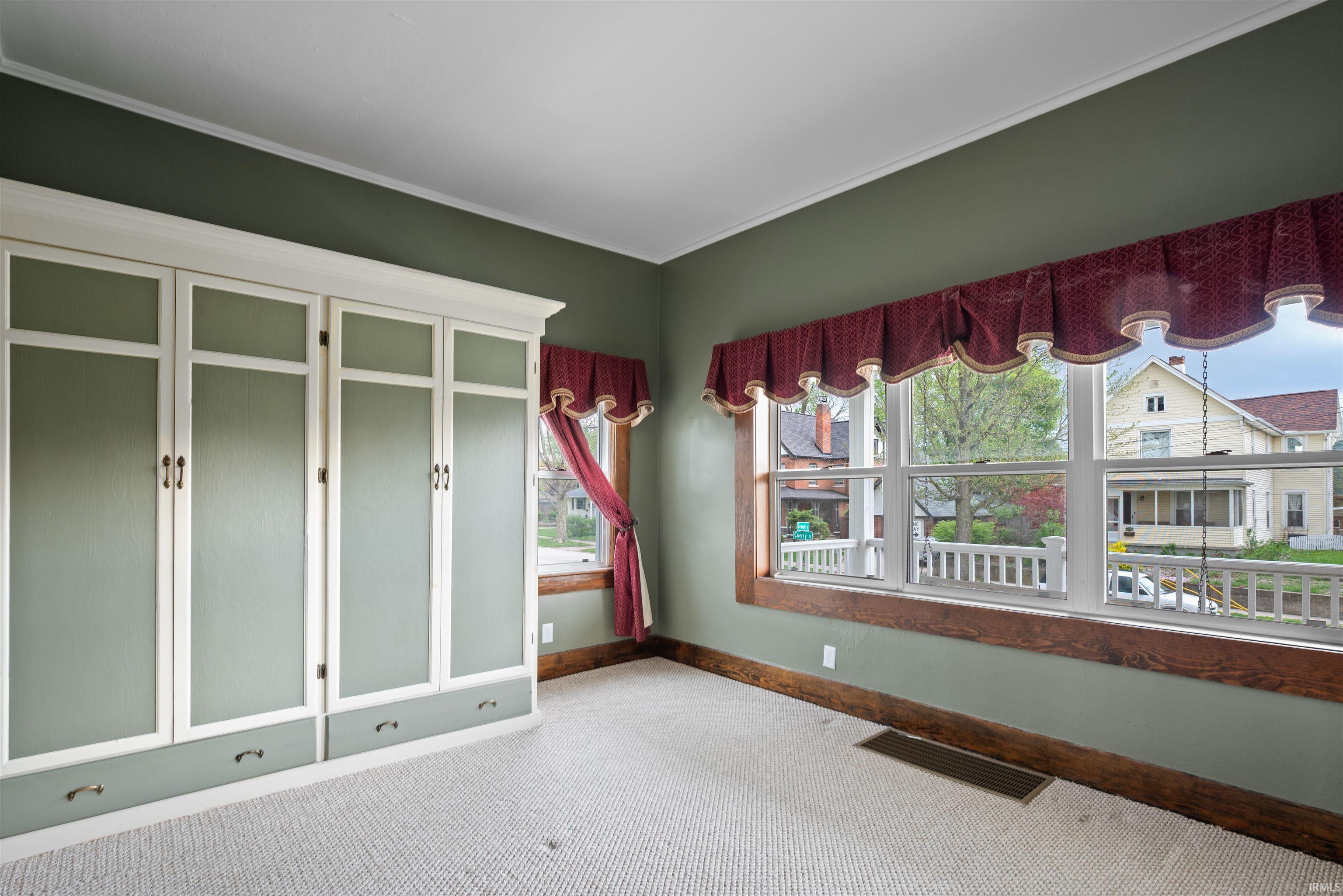 Carpeted empty room featuring baseboards and ornamental molding
