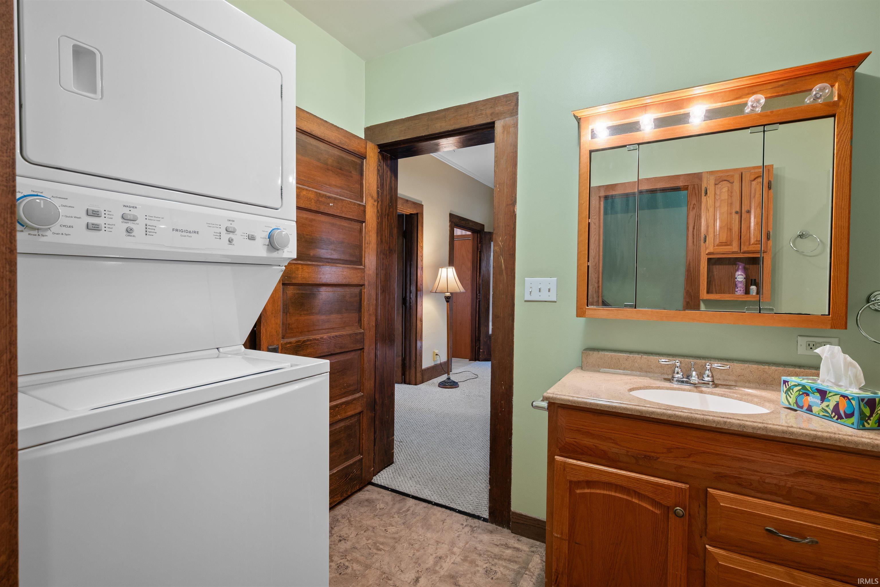 Bathroom featuring vanity and stacked washer / dryer