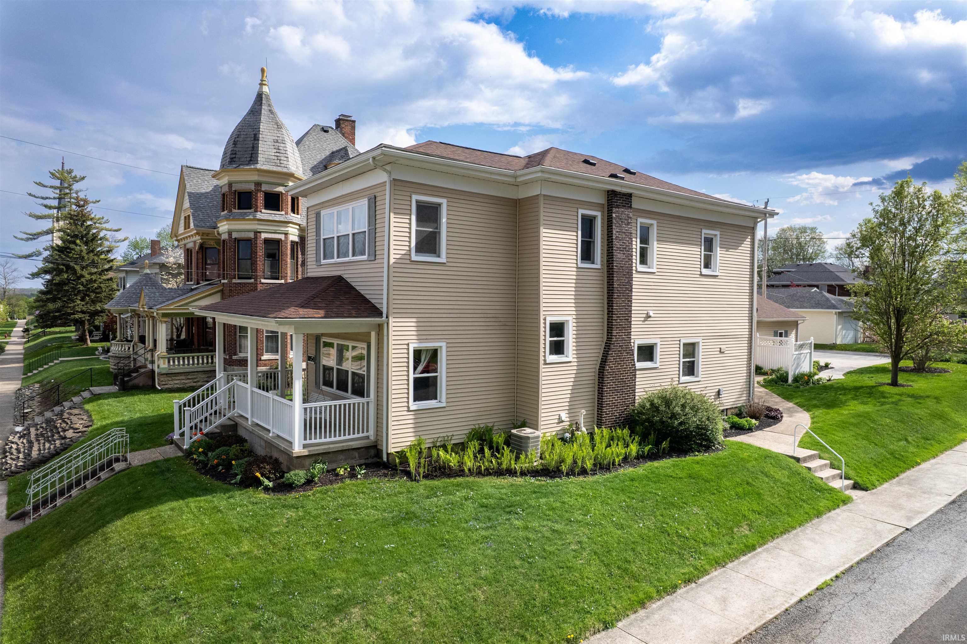 View of home's exterior featuring a porch and a lawn
