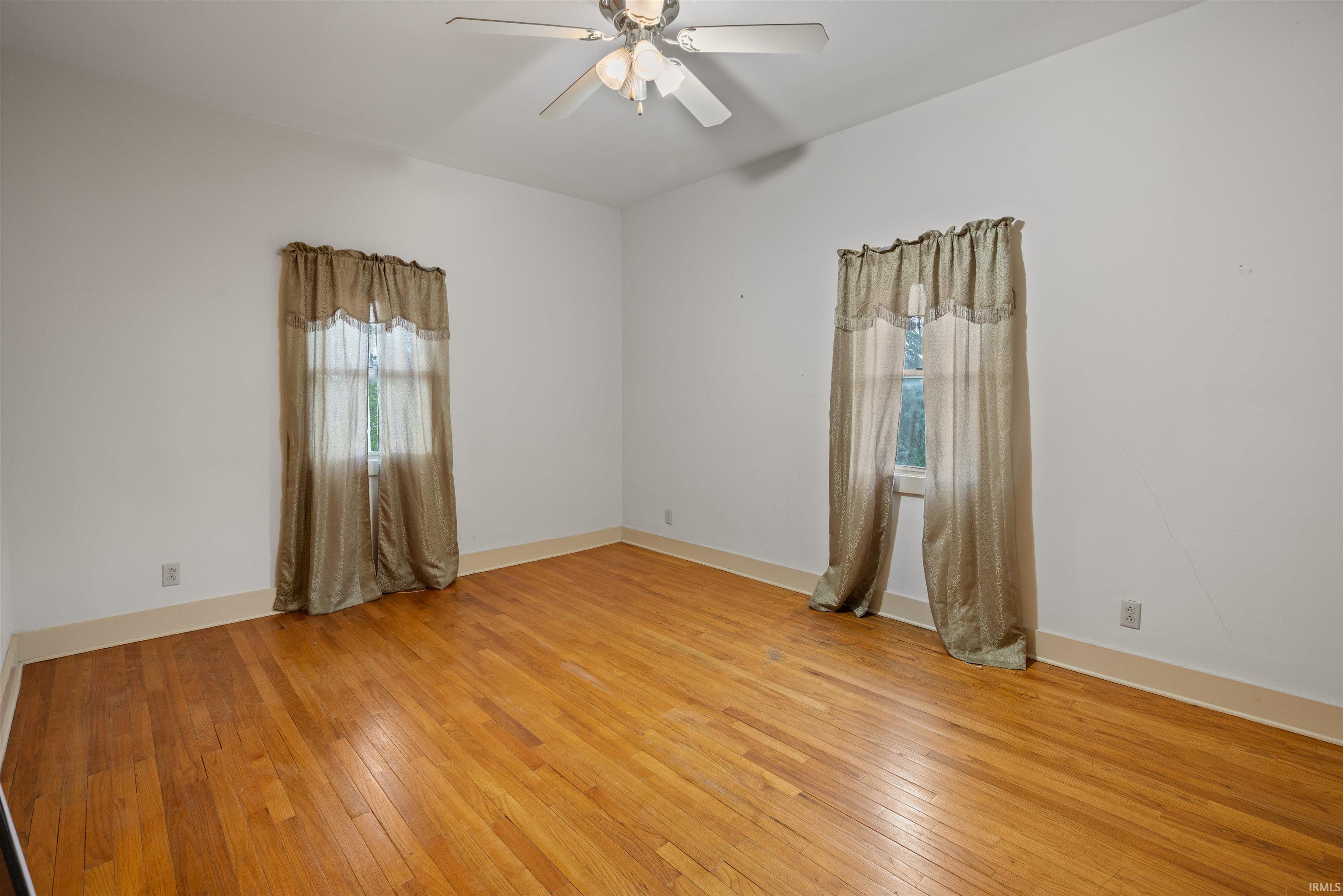 Spare room with light wood-style flooring, healthy amount of natural light, and ceiling fan