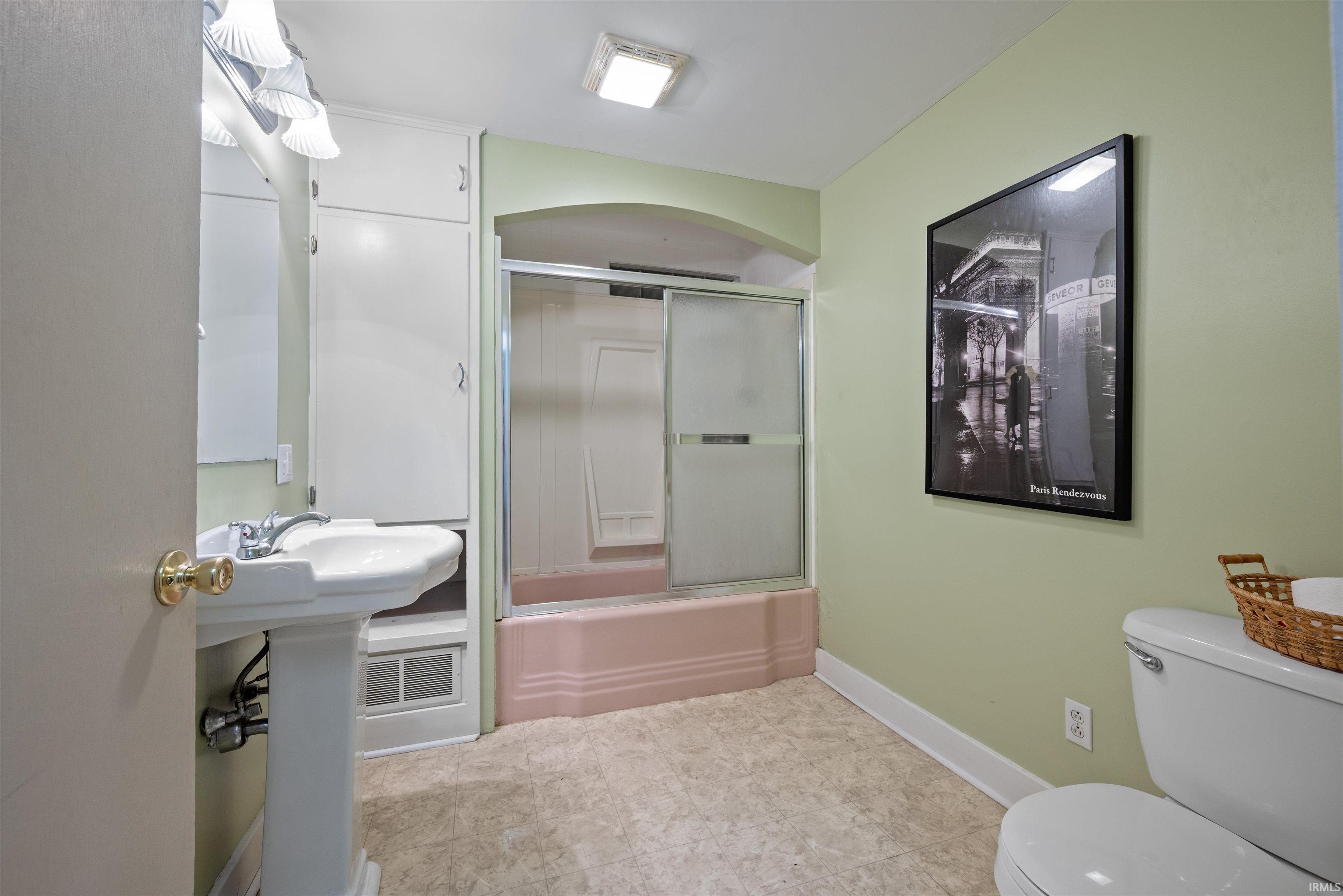 Full bath with toilet and shower / bath combination with glass door