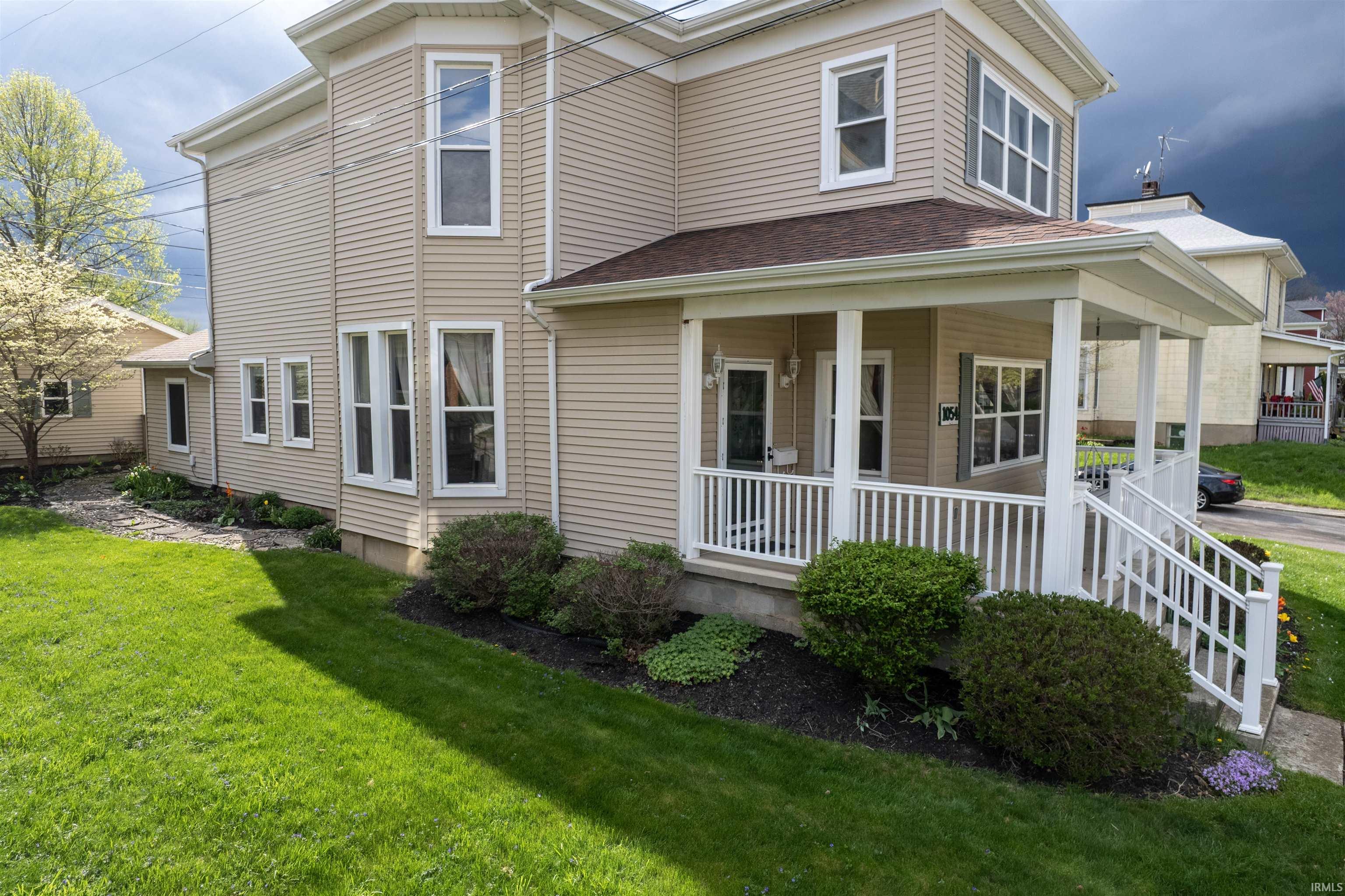 View of front of property with a front yard and covered porch