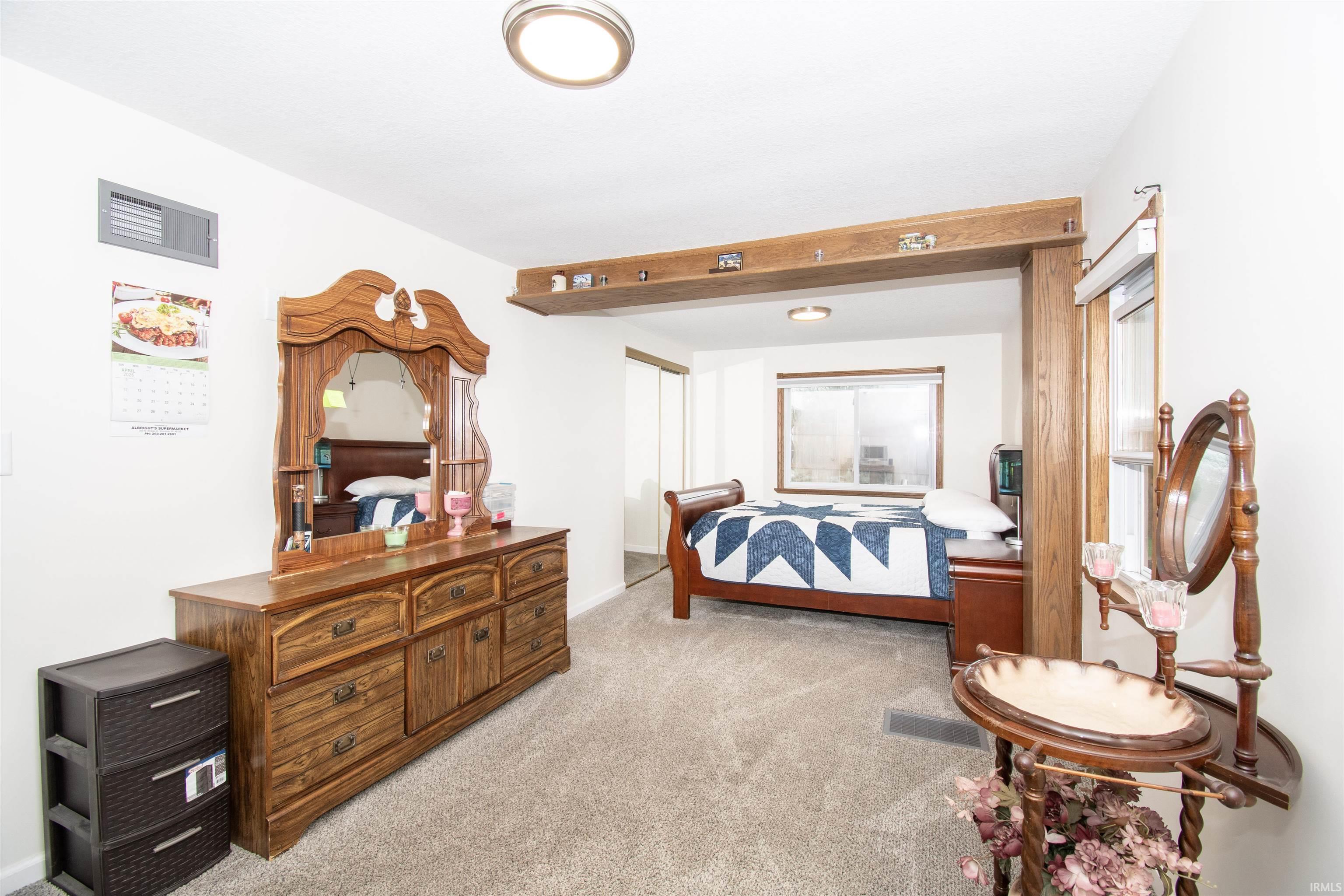 Bedroom with light colored carpet and baseboards