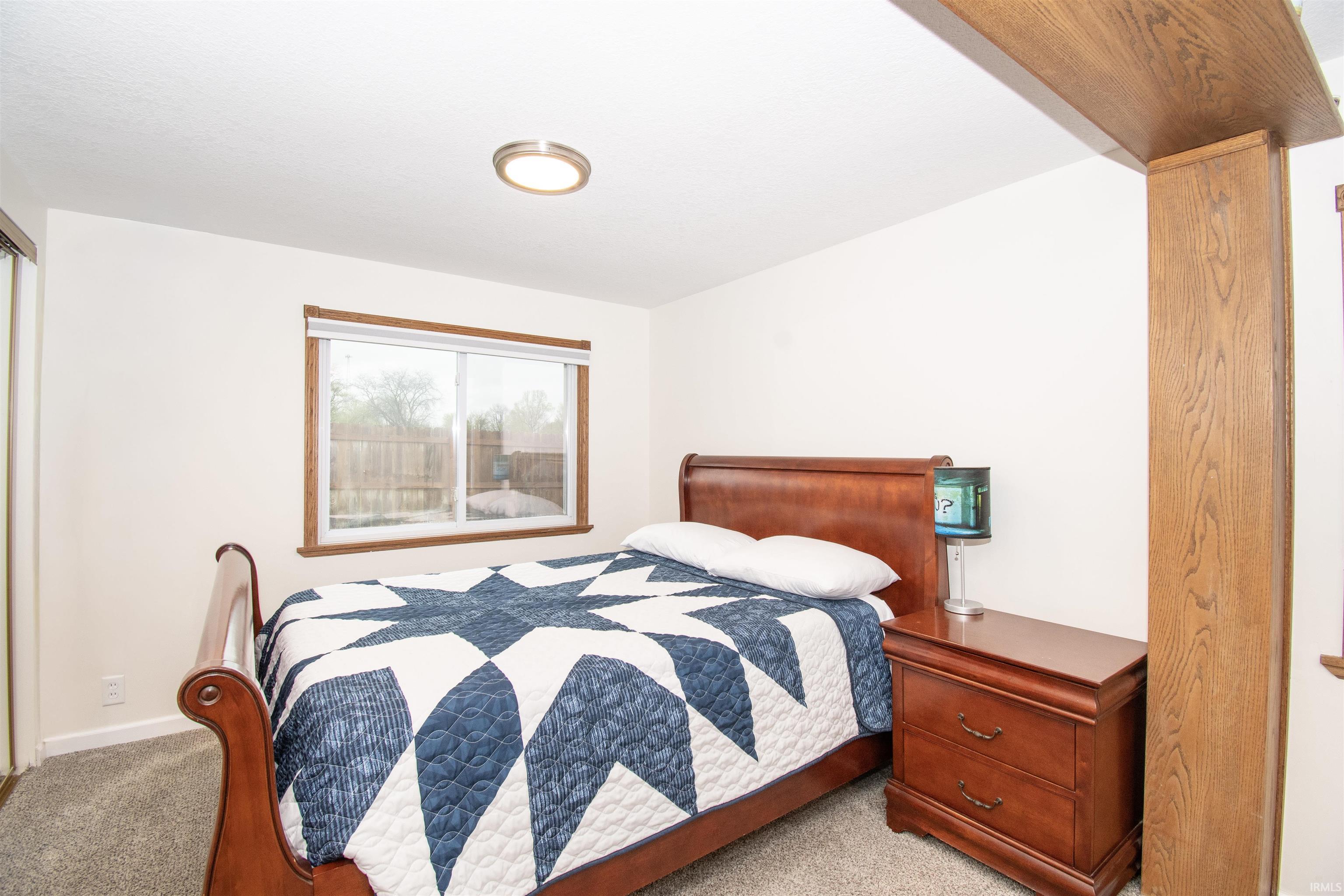 Bedroom featuring light carpet and baseboards