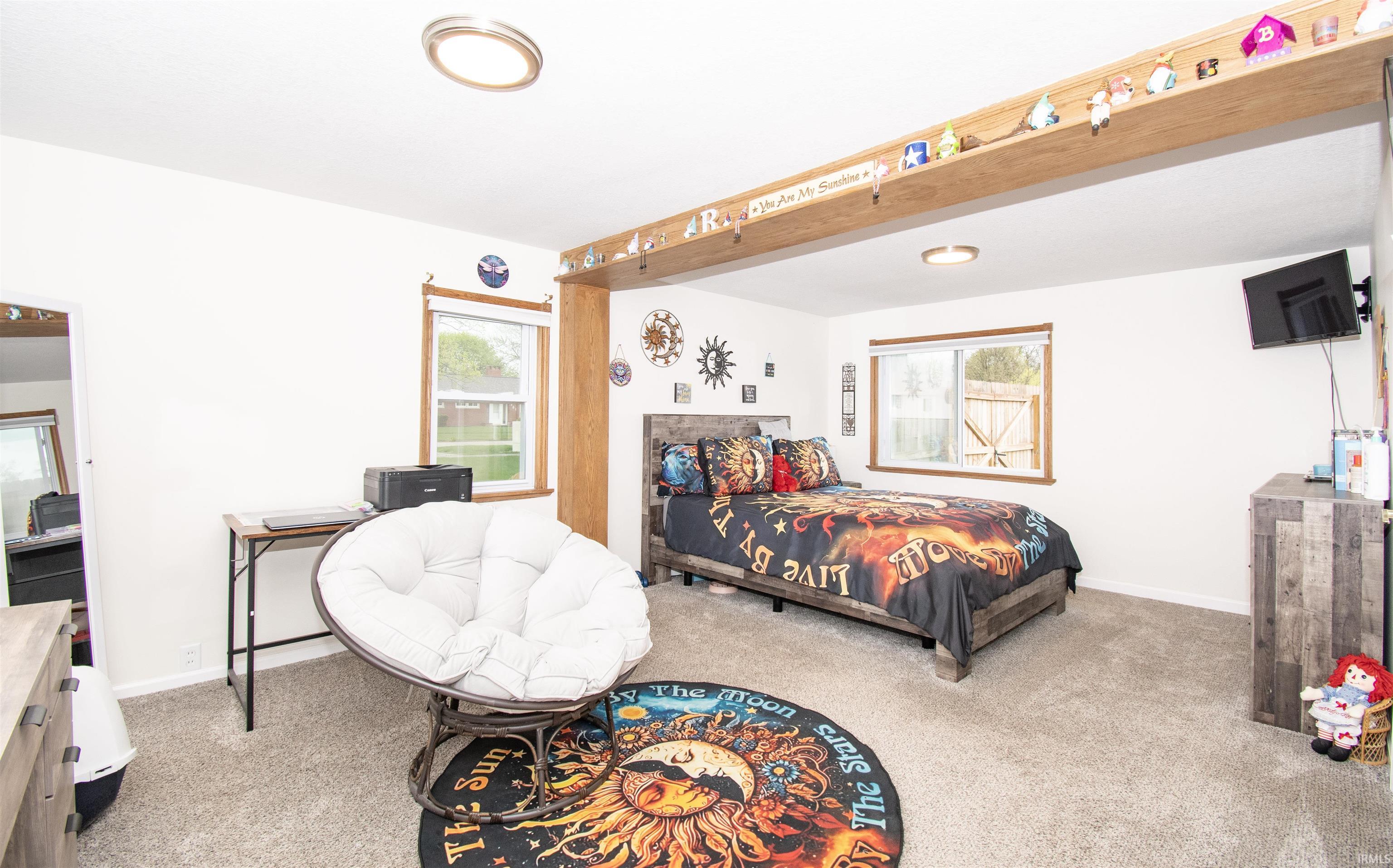 Bedroom with carpet and multiple windows