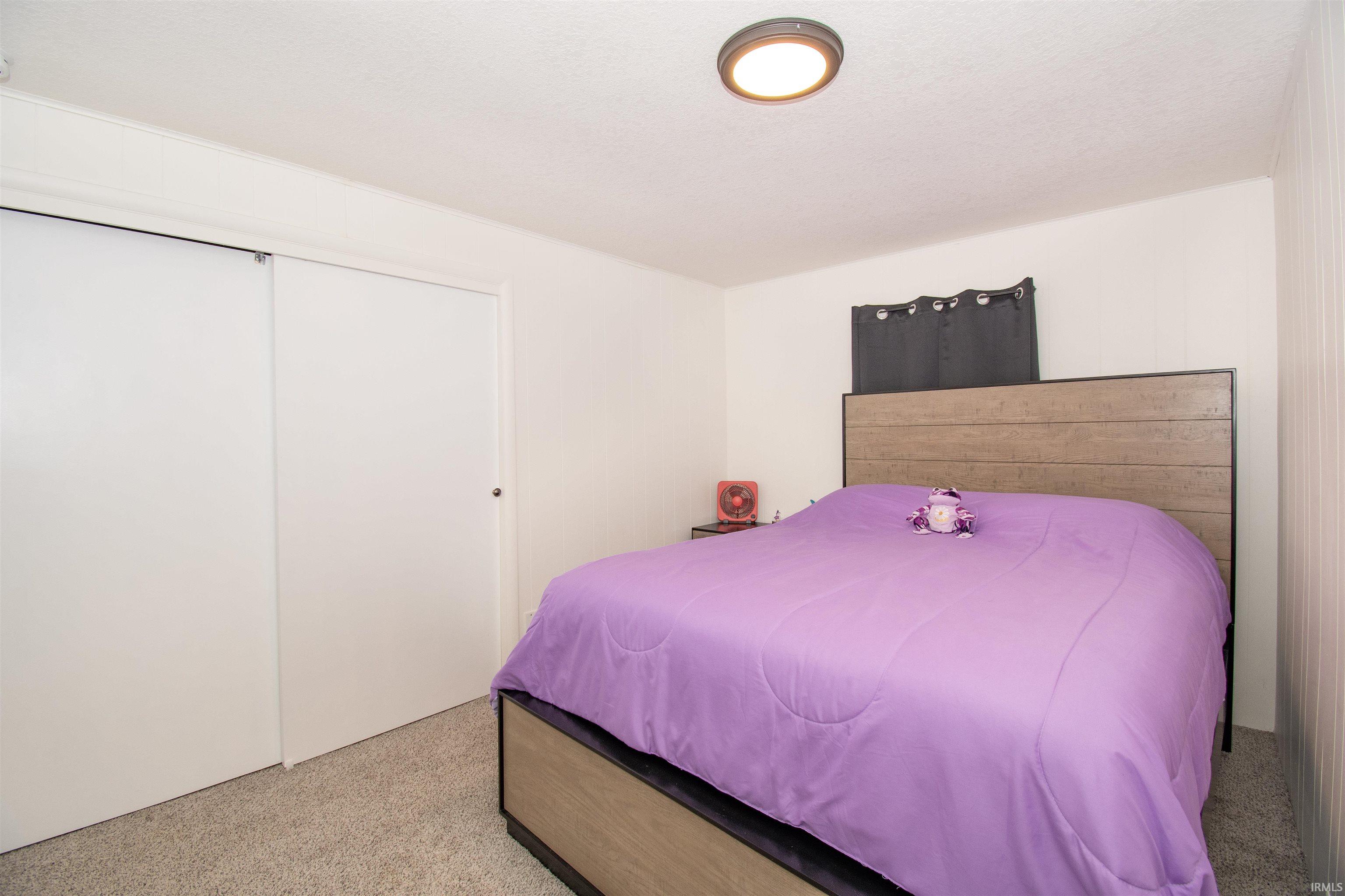 Bedroom with light carpet and a closet
