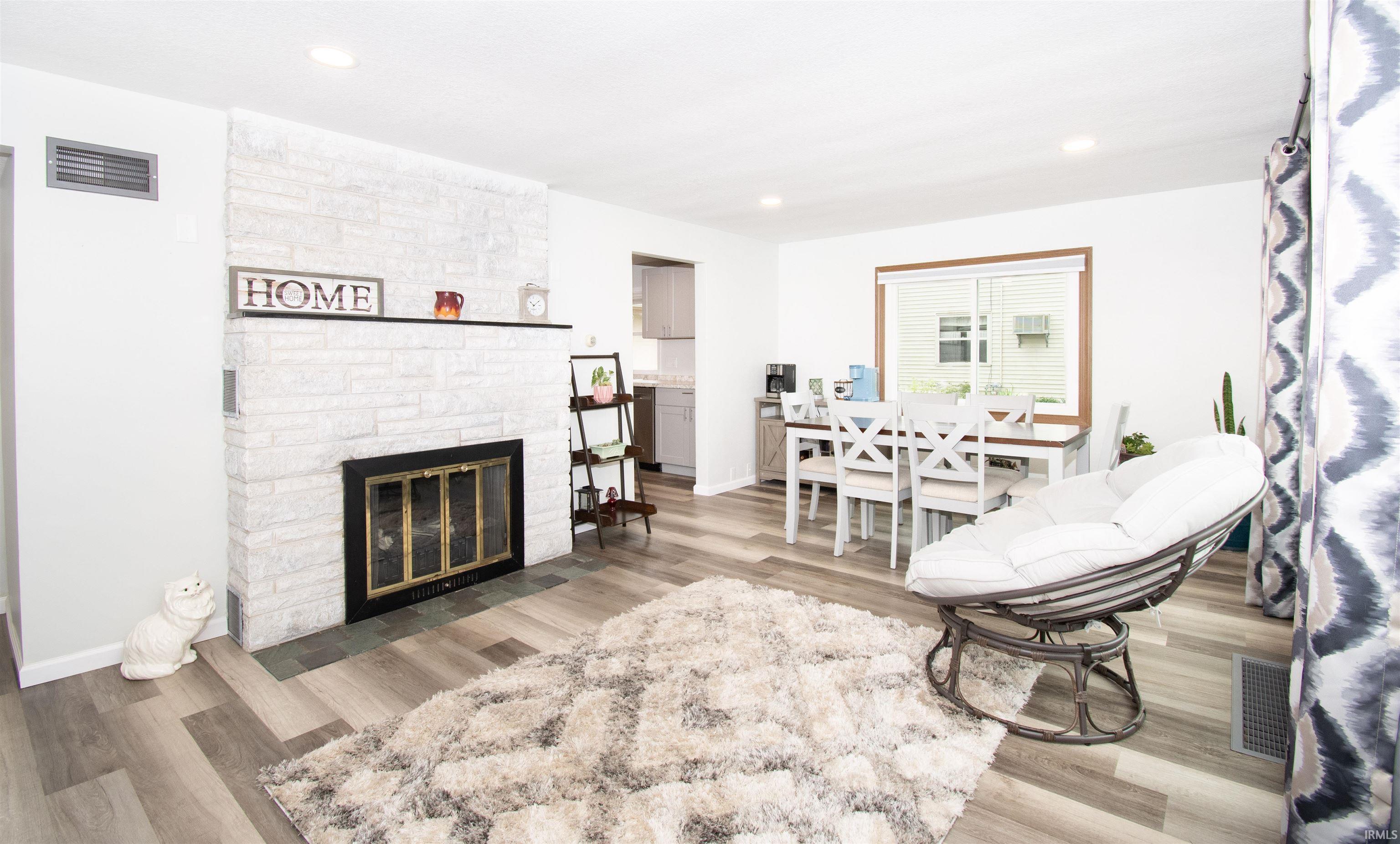 Living room featuring light wood finished floors, a fireplace, and recessed lighting