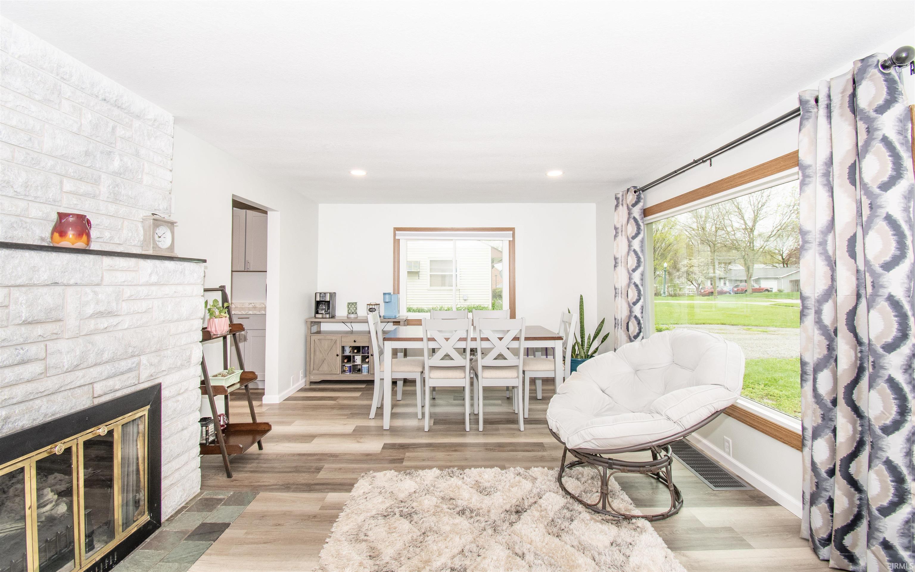 Sitting room featuring light wood-style floors, healthy amount of natural light, a fireplace, and recessed lighting
