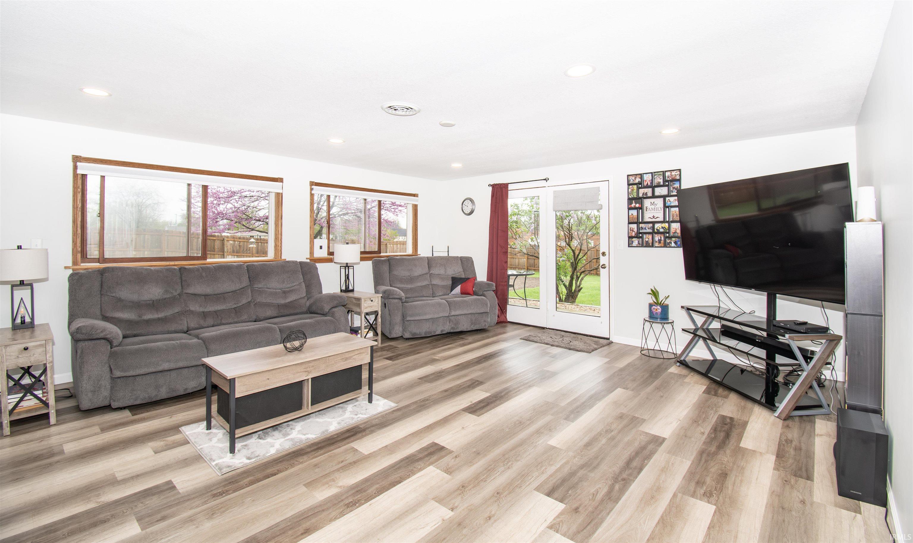 Living area with light wood-style floors and recessed lighting