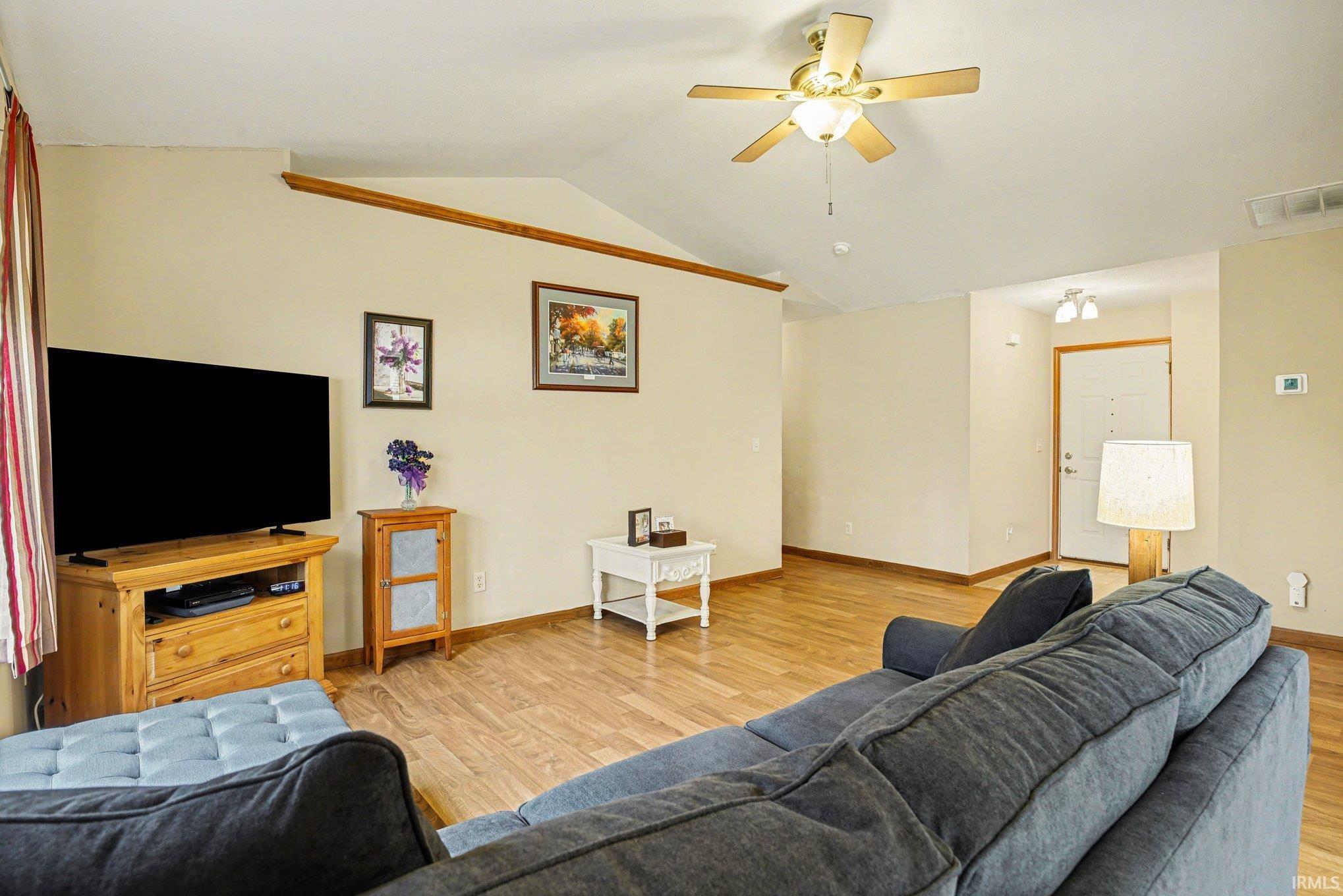 Living room with ceiling fan and light wood-style floors