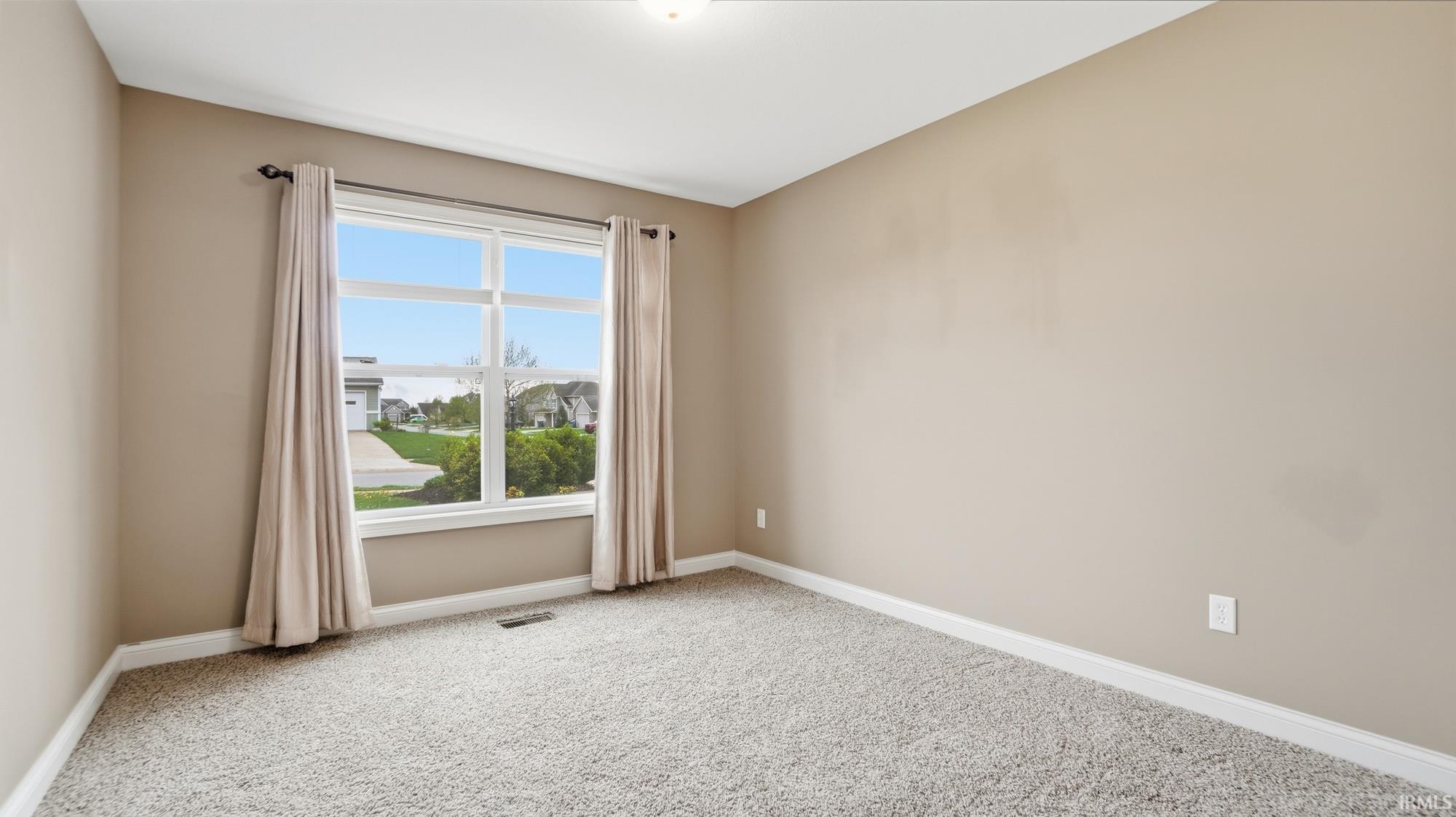 Unfurnished room with baseboards and light carpet