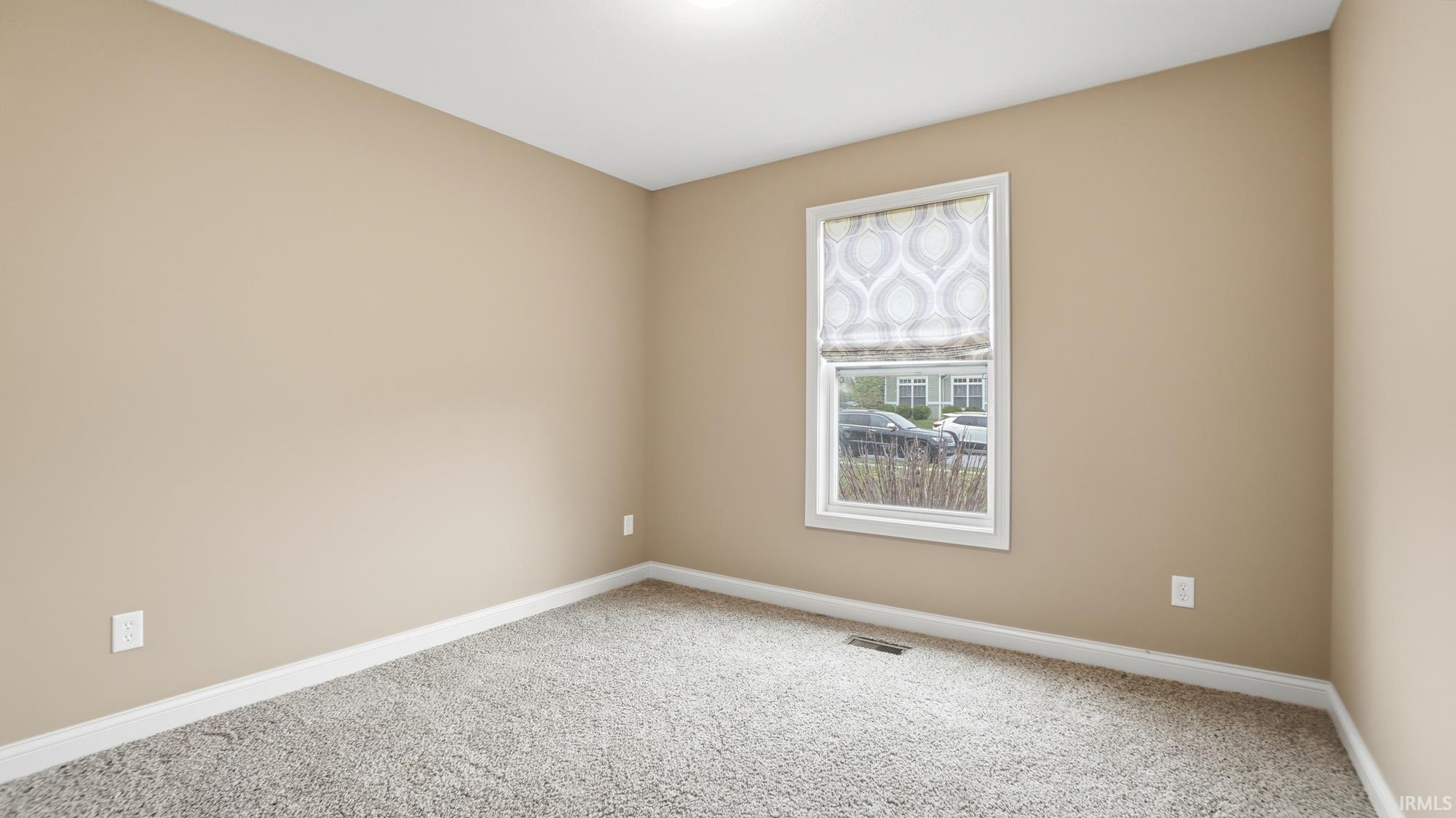 Empty room featuring baseboards and light colored carpet