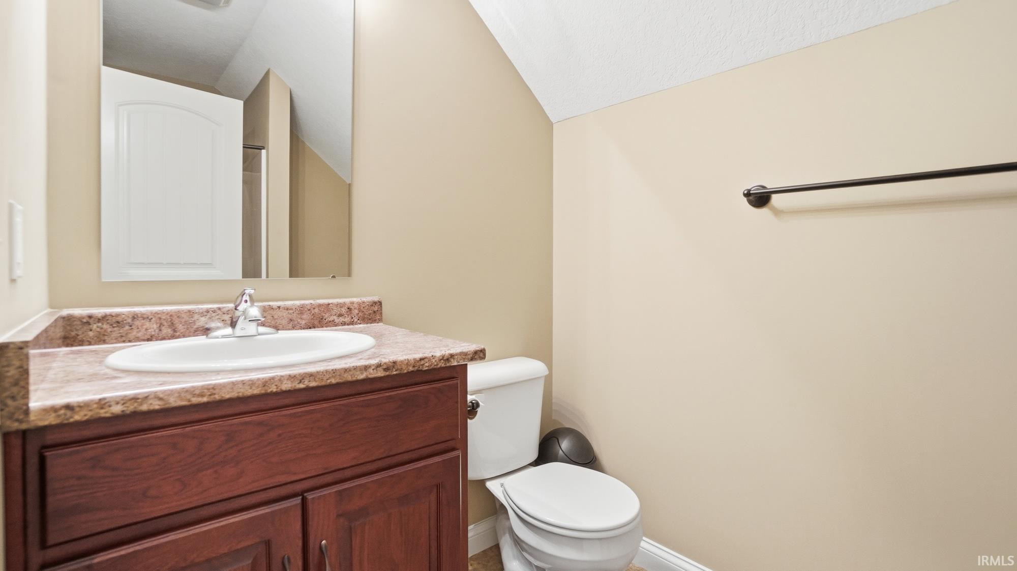 Bathroom featuring vanity and vaulted ceiling