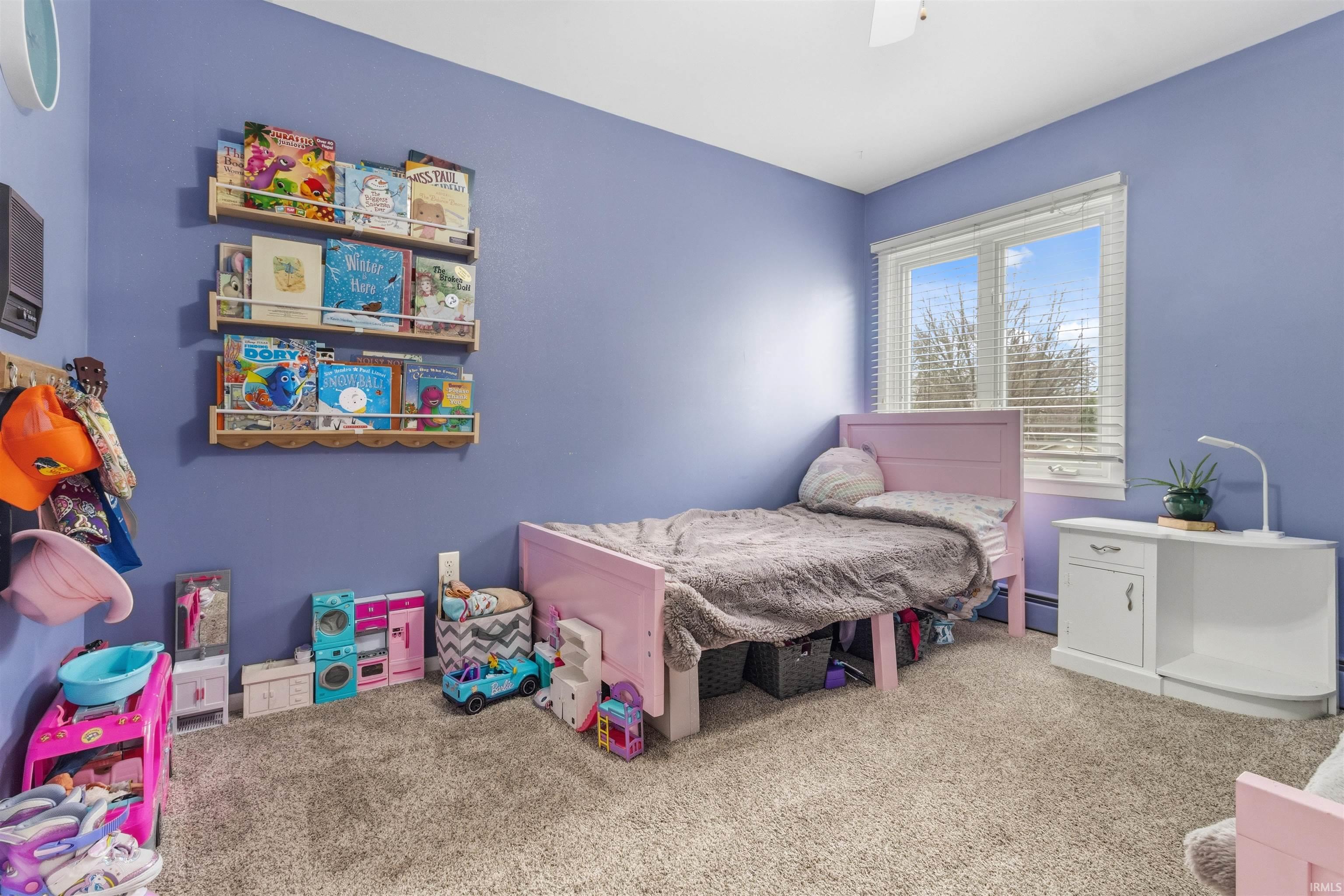 Carpeted bedroom featuring ceiling fan