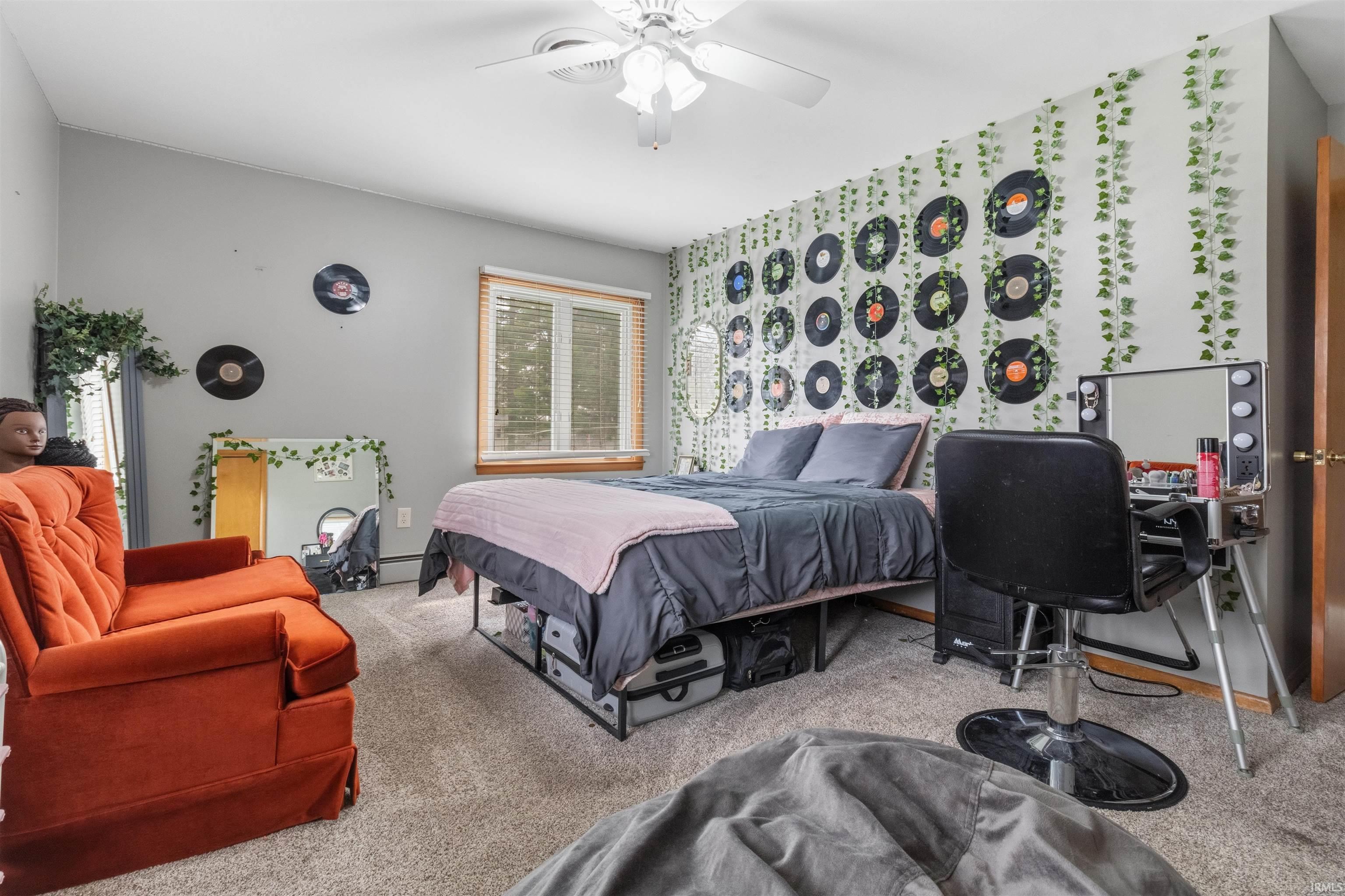 Carpeted bedroom with a ceiling fan, wallpapered walls, and an accent wall