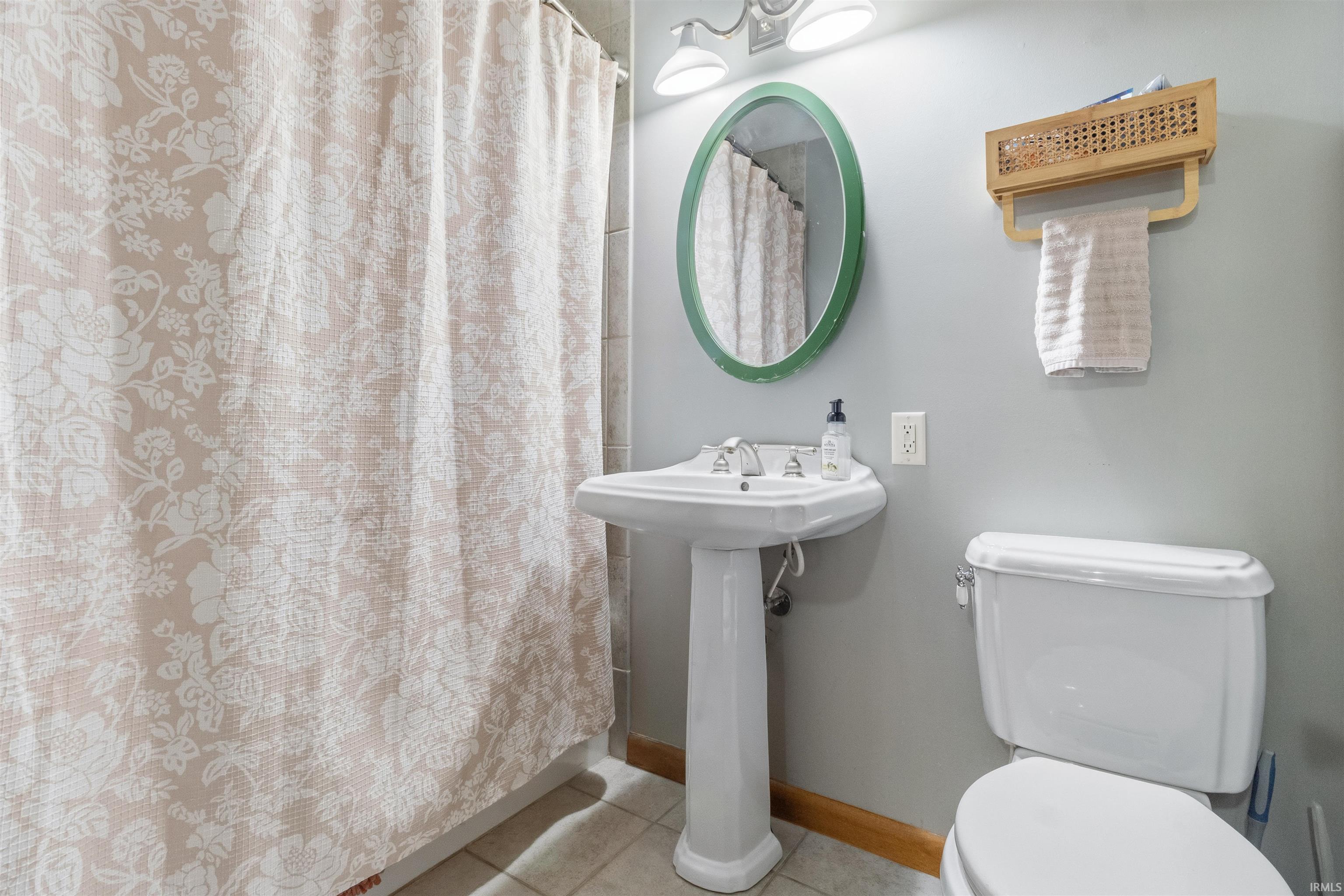 Bathroom featuring a shower with shower curtain and light tile patterned floors