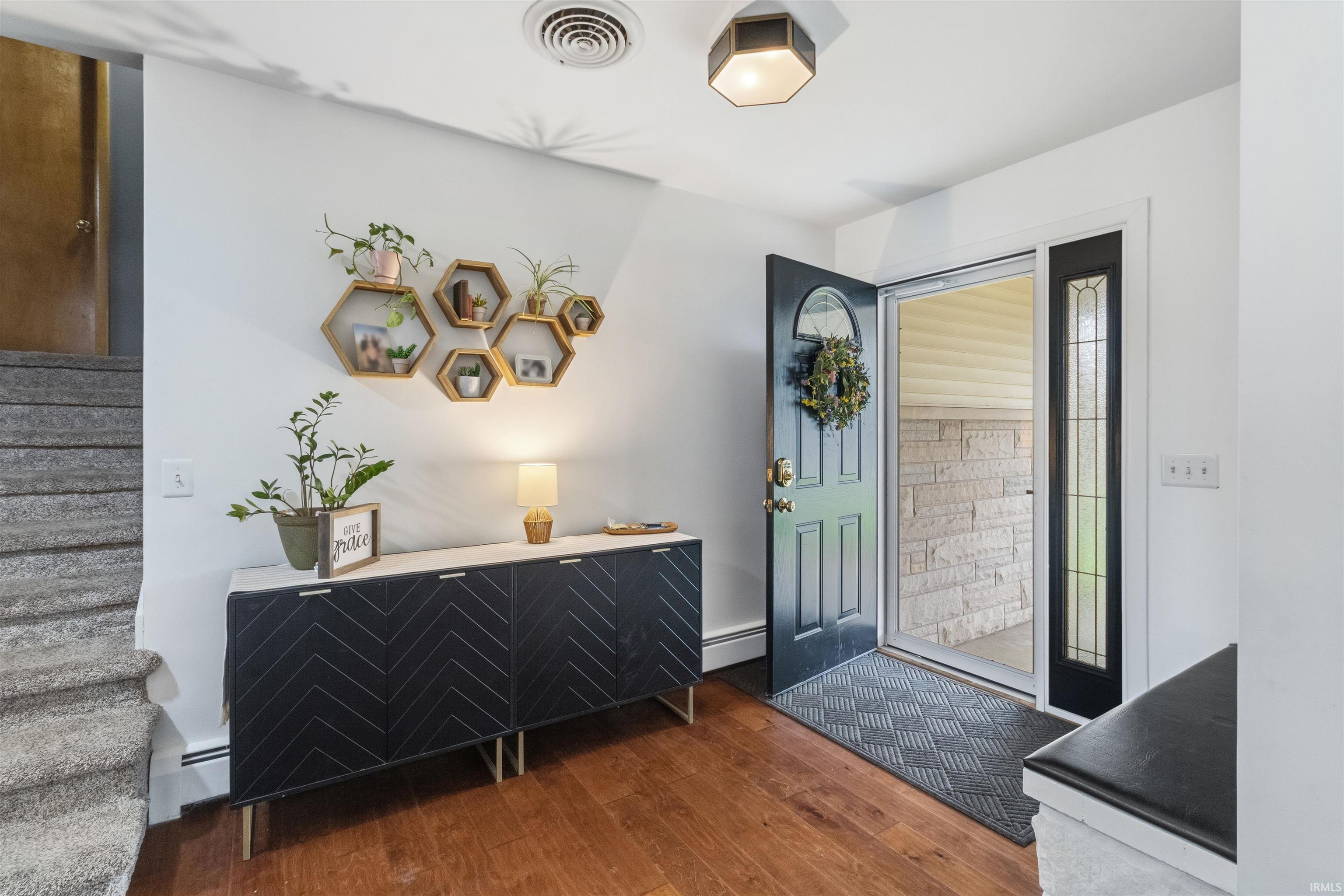 Foyer entrance with a baseboard radiator and dark wood finished floors