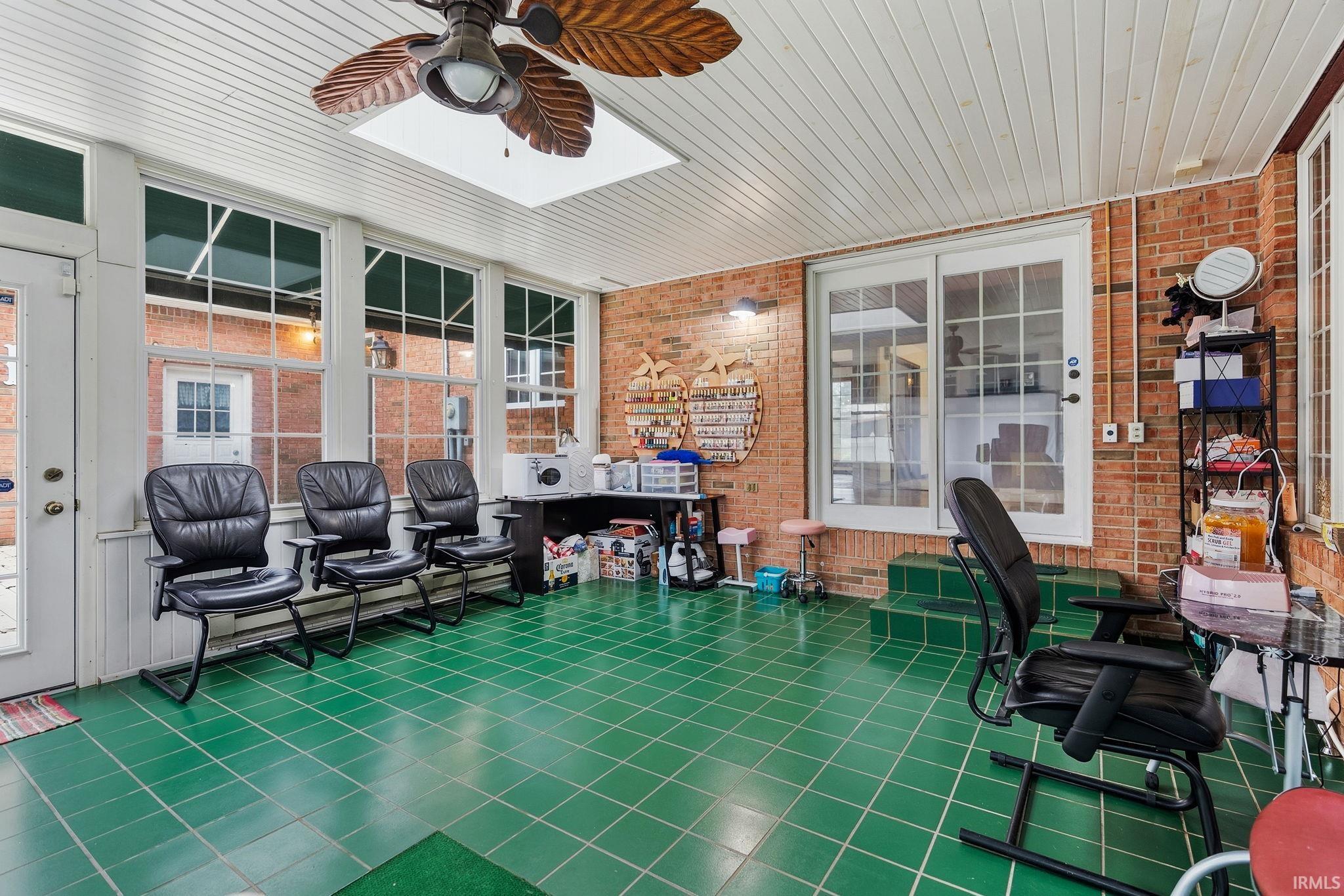 Sunroom / solarium with a ceiling fan and a patio area