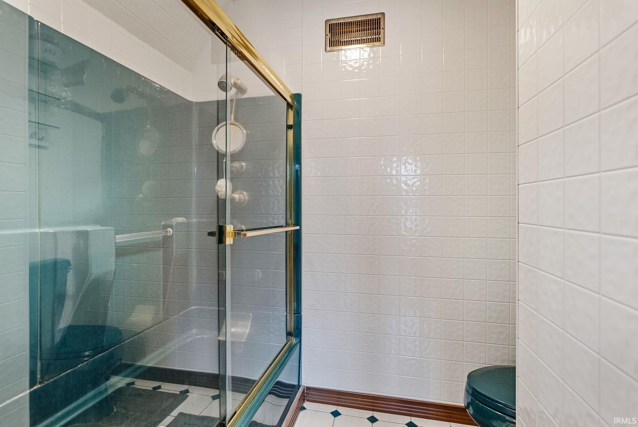 Bathroom featuring a shower stall and toilet