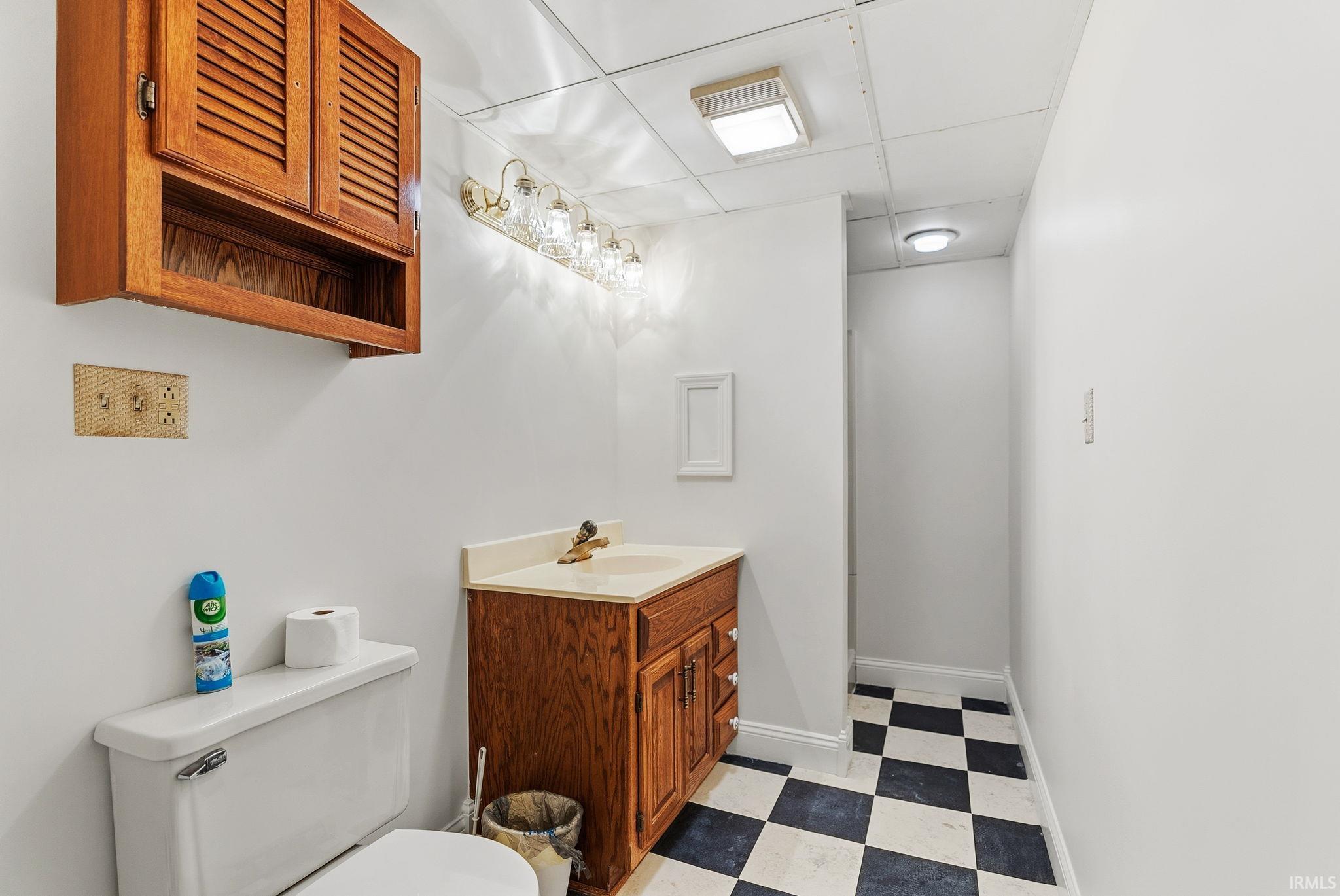 Bathroom featuring light floors, a paneled ceiling, and vanity