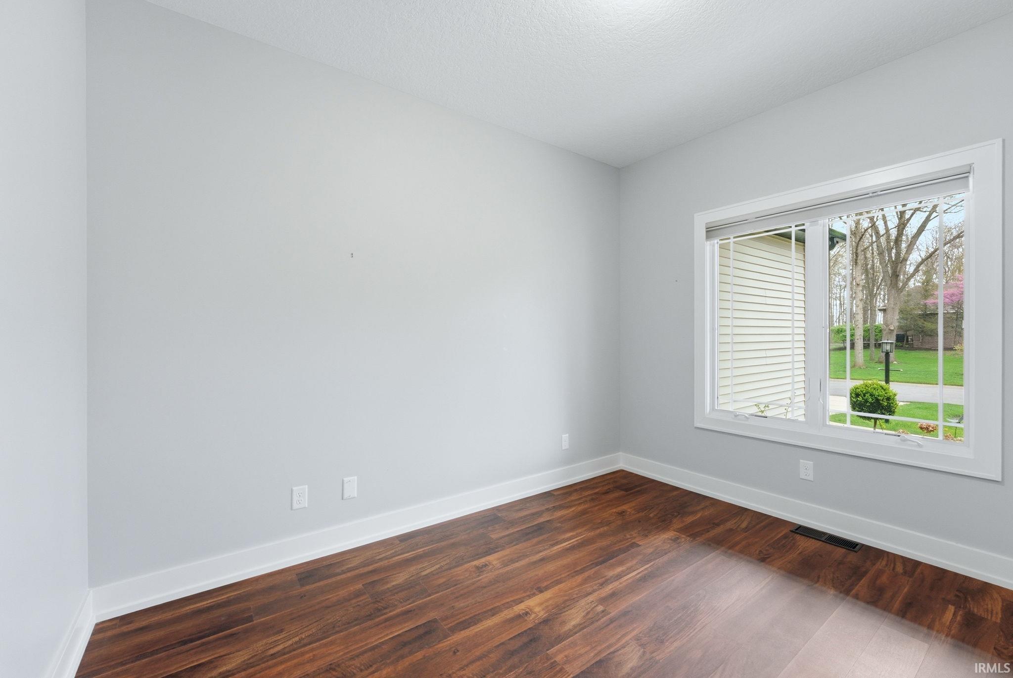 Spare room featuring dark wood-style floors and a textured ceiling