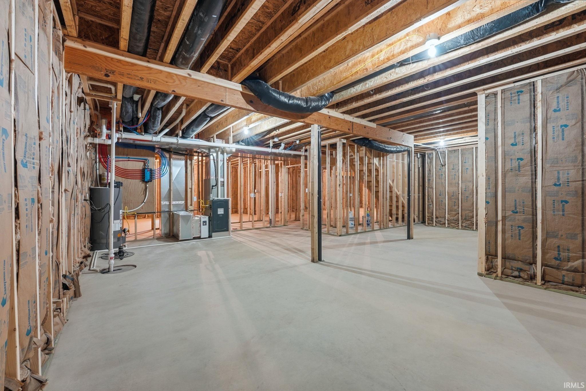 Unfinished below grade area featuring water heater