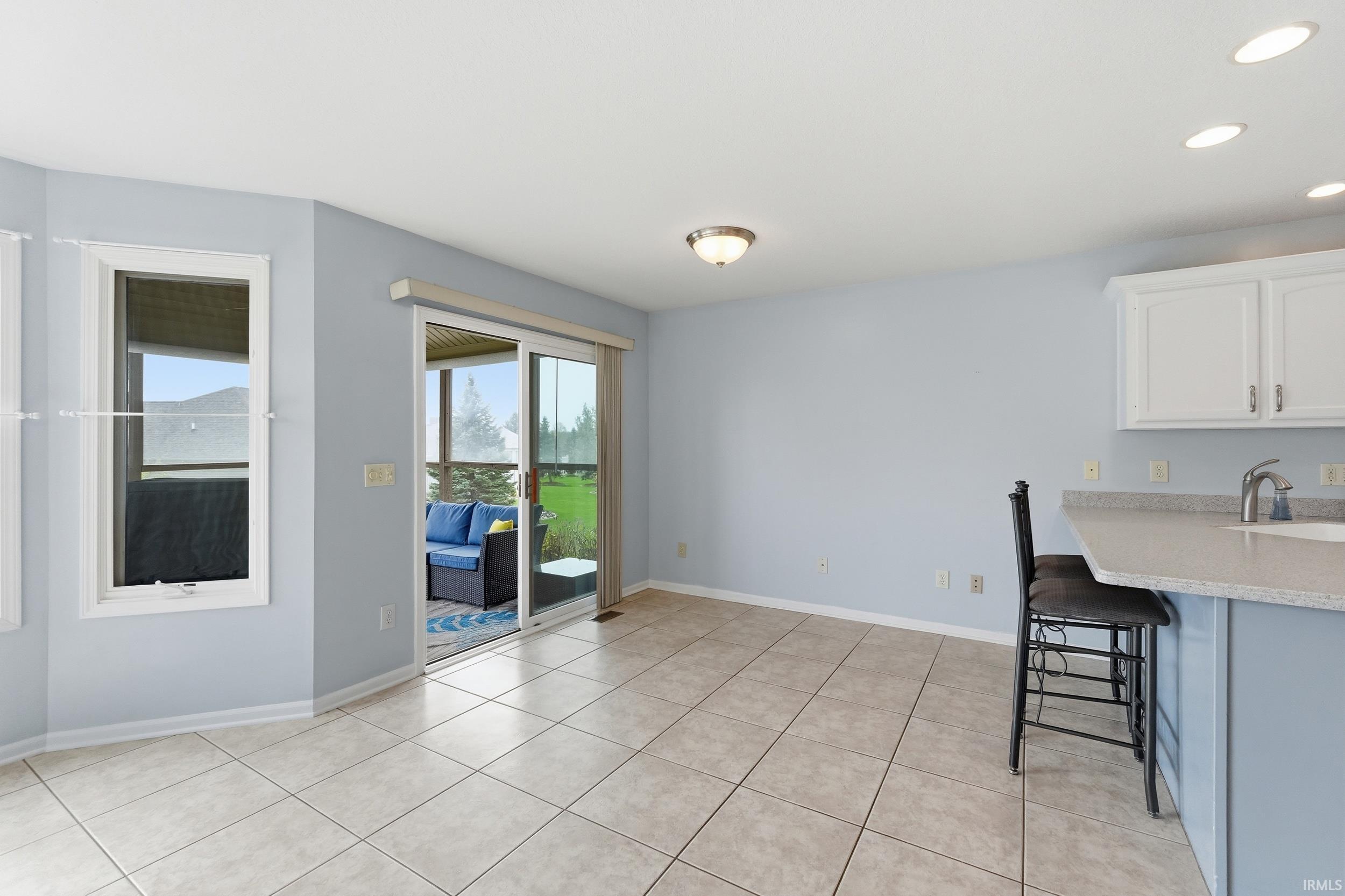 Unfurnished dining area with light tile patterned floors and recessed lighting