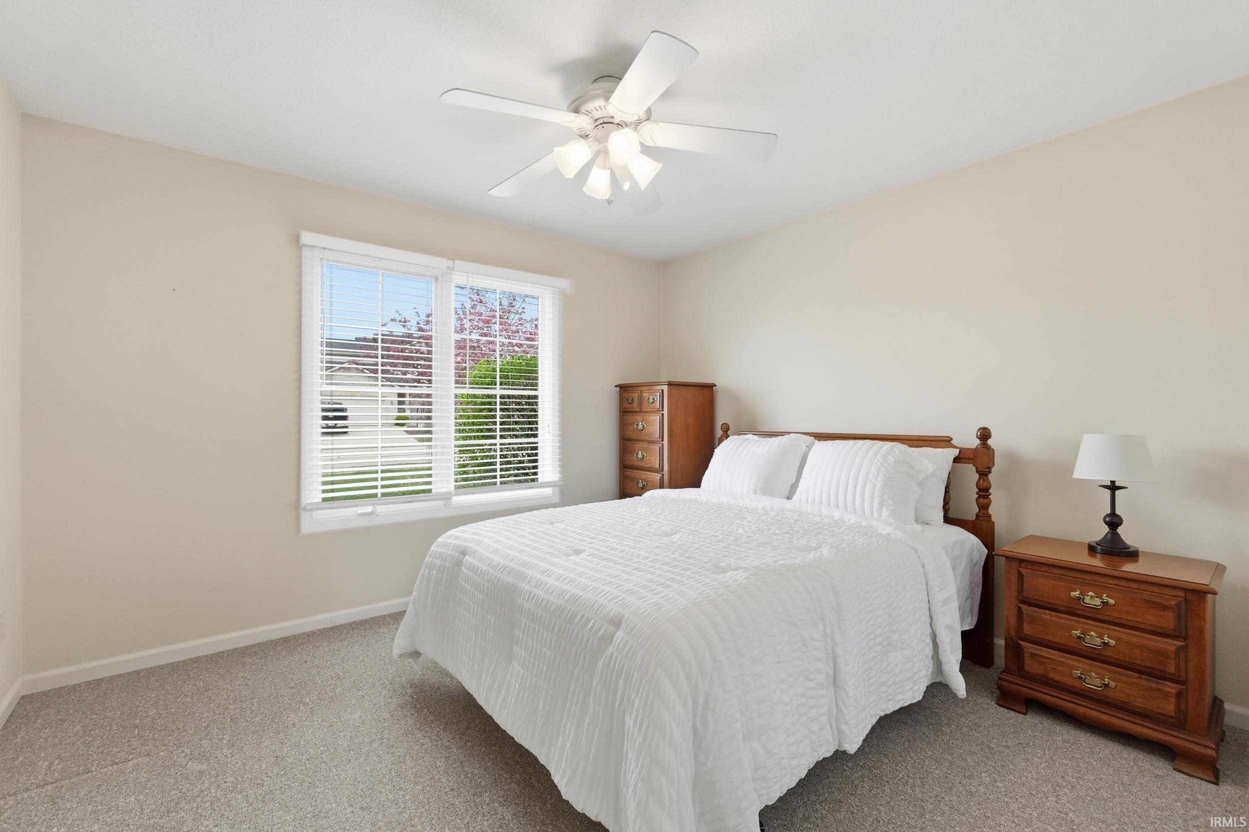 Bedroom with light carpet and ceiling fan