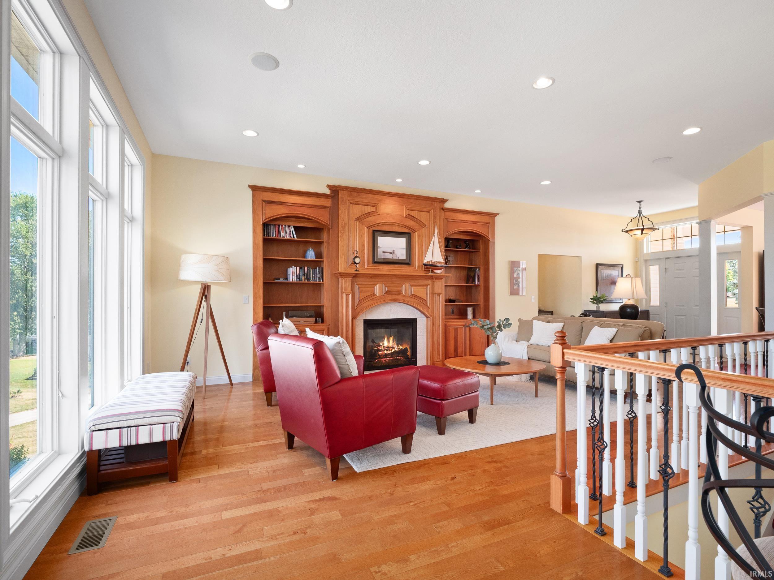 Living area with a glass covered fireplace, light wood-style flooring, and recessed lighting
