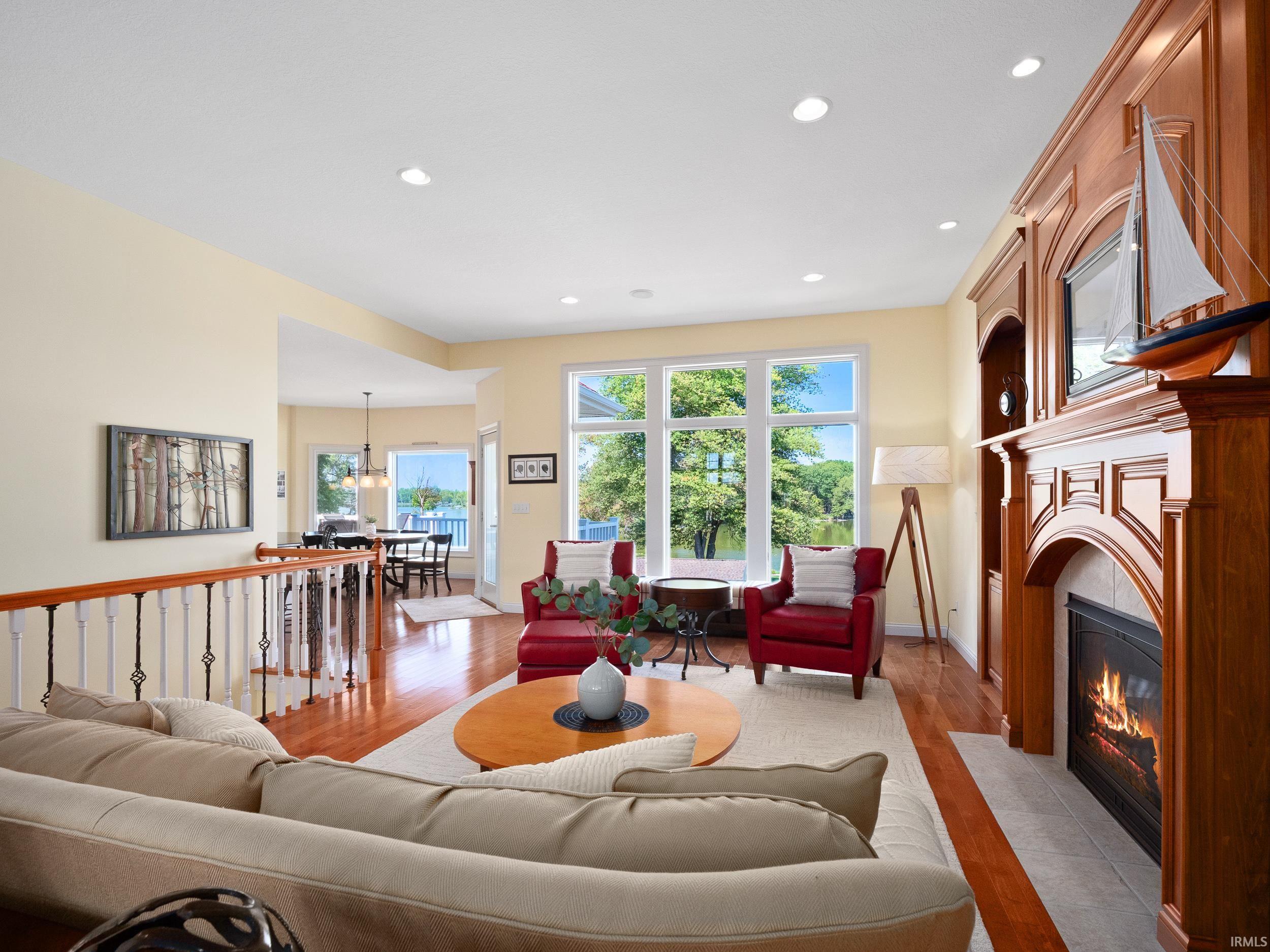 Living room featuring hardwood / wood-style floors, recessed lighting, a tile fireplace, and a chandelier