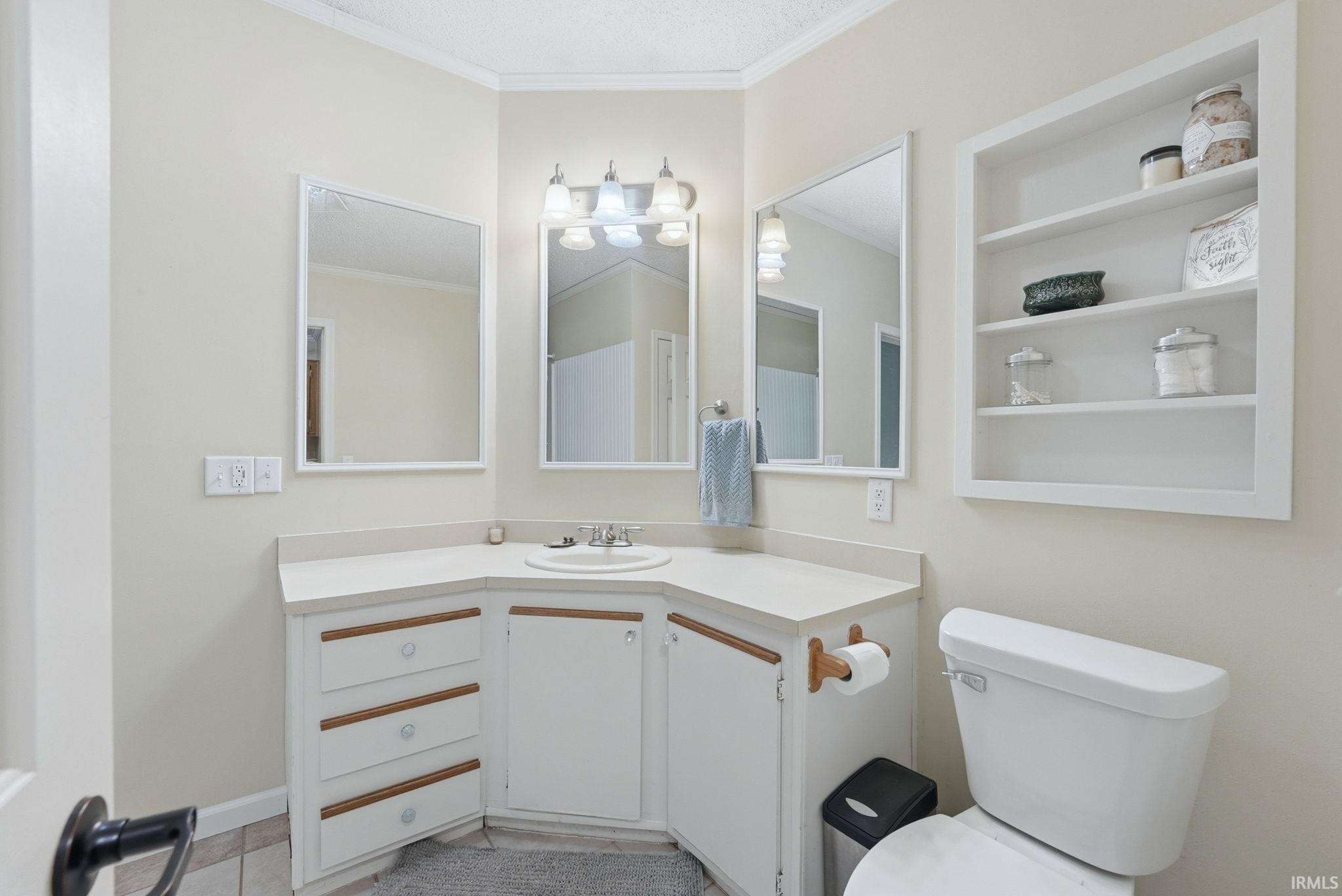Bathroom with vanity, crown molding, and built in features