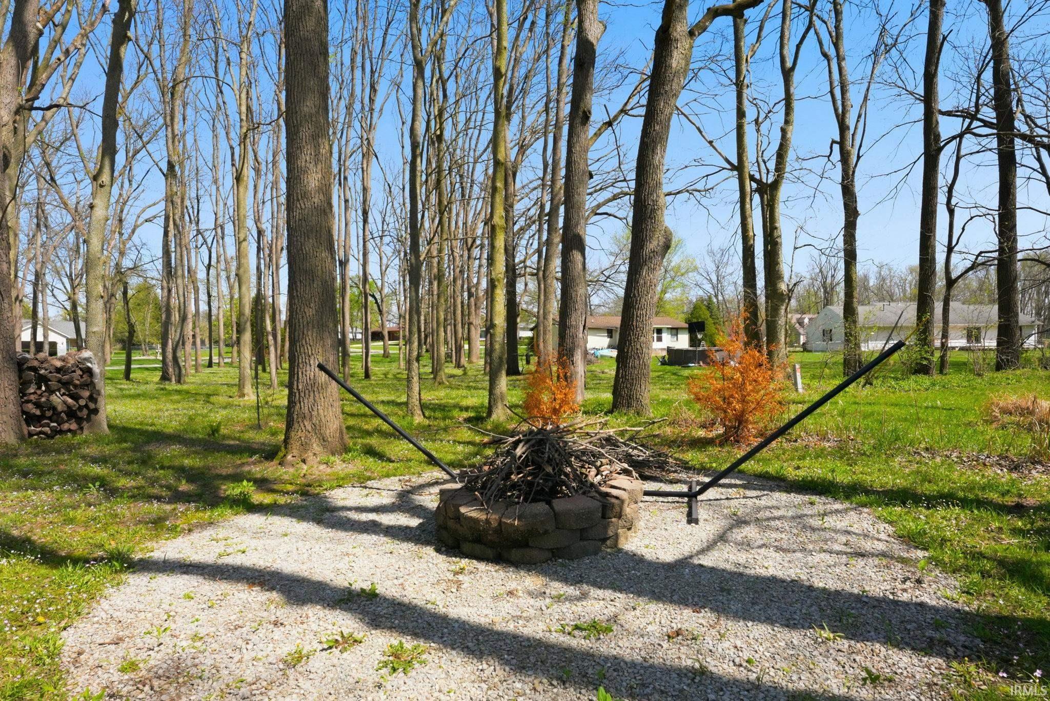 View of grassy yard with an outdoor fire pit
