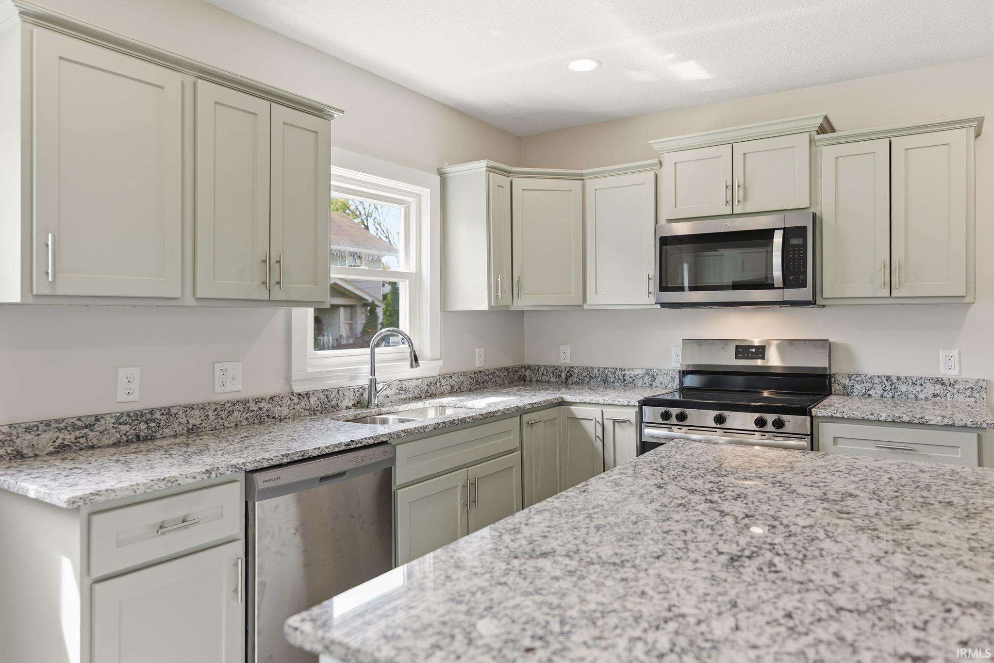 Kitchen featuring stainless steel appliances, light stone countertops, and recessed lighting