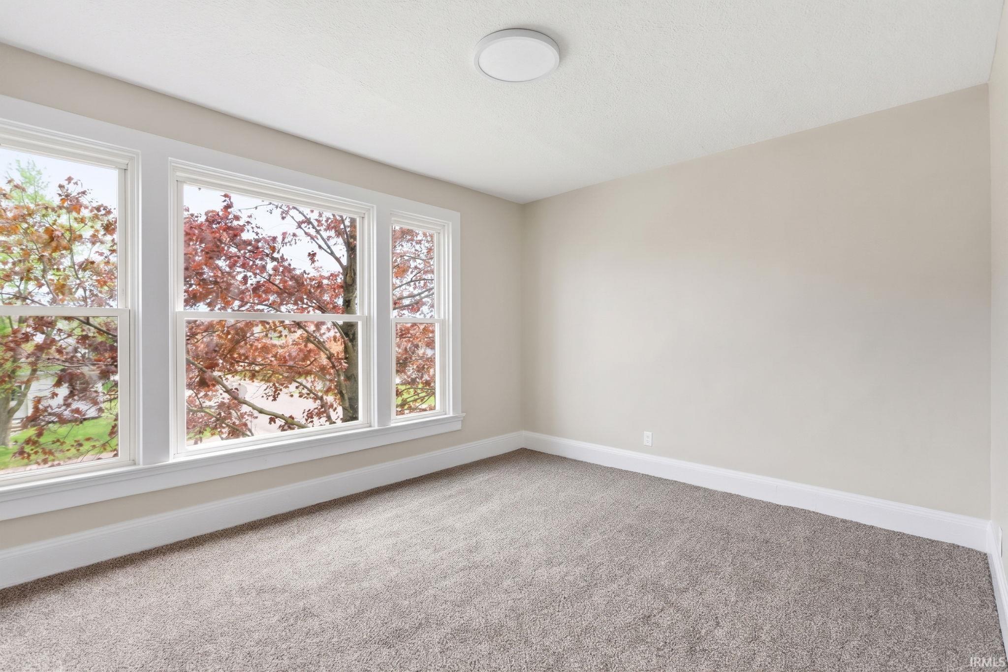 bedroom featuring light colored carpet and baseboards