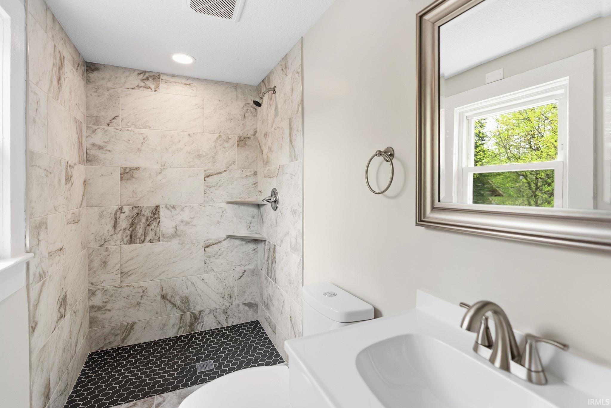 Bathroom with vanity and a tile shower stall