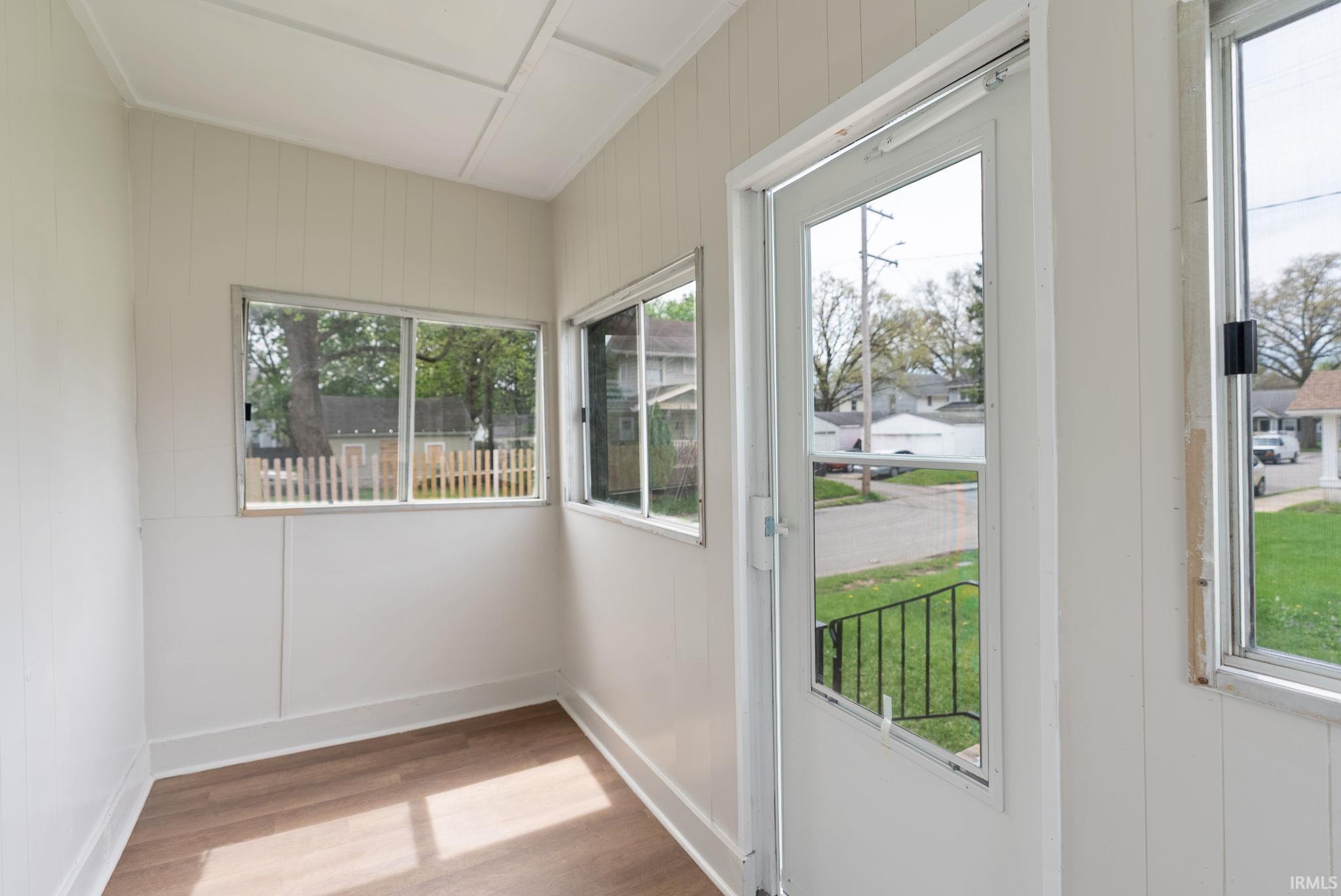 Backyard Entryway featuring wood finished floors and baseboards
