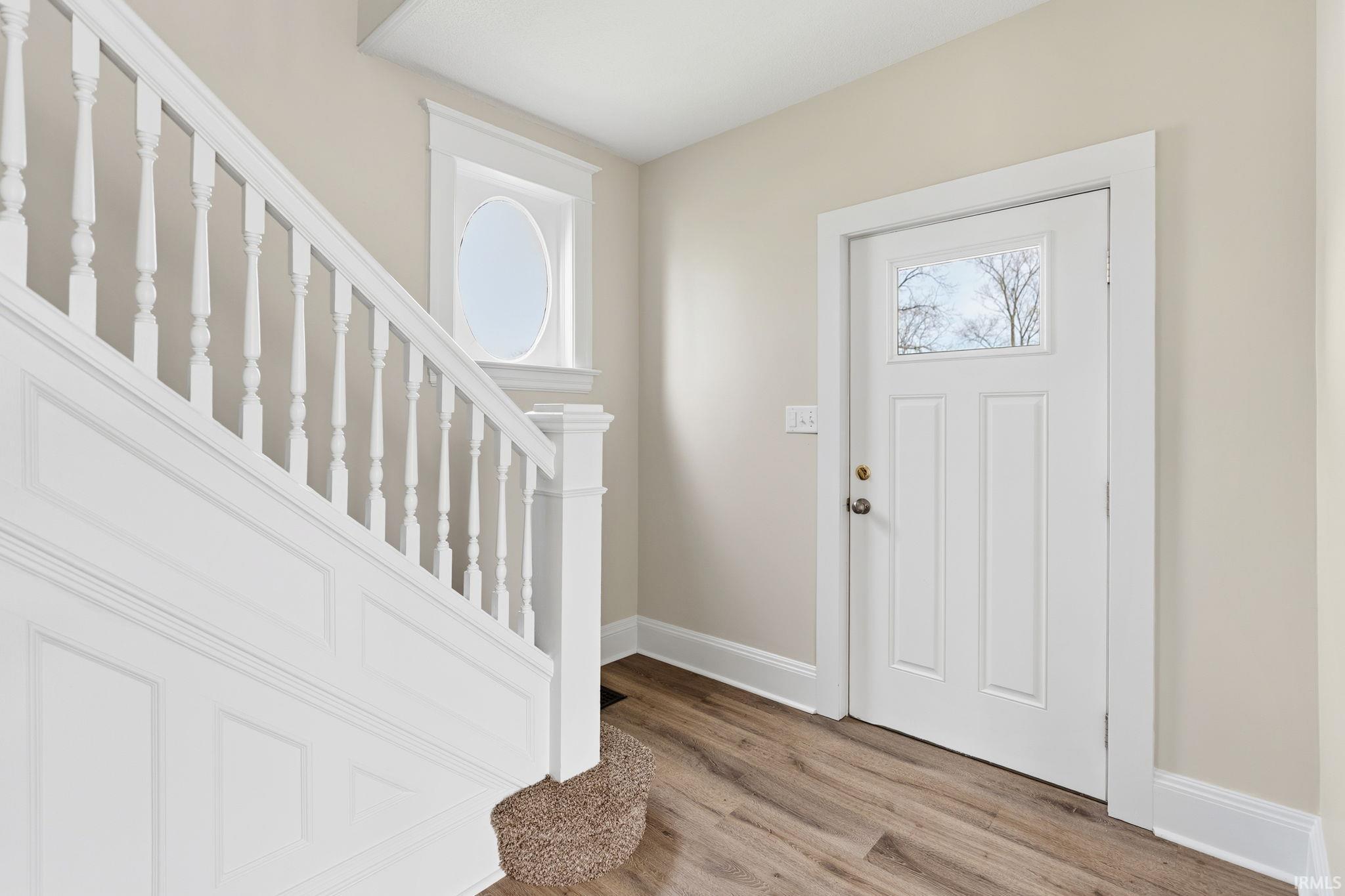 Foyer entrance with stairway and light wood finished floors