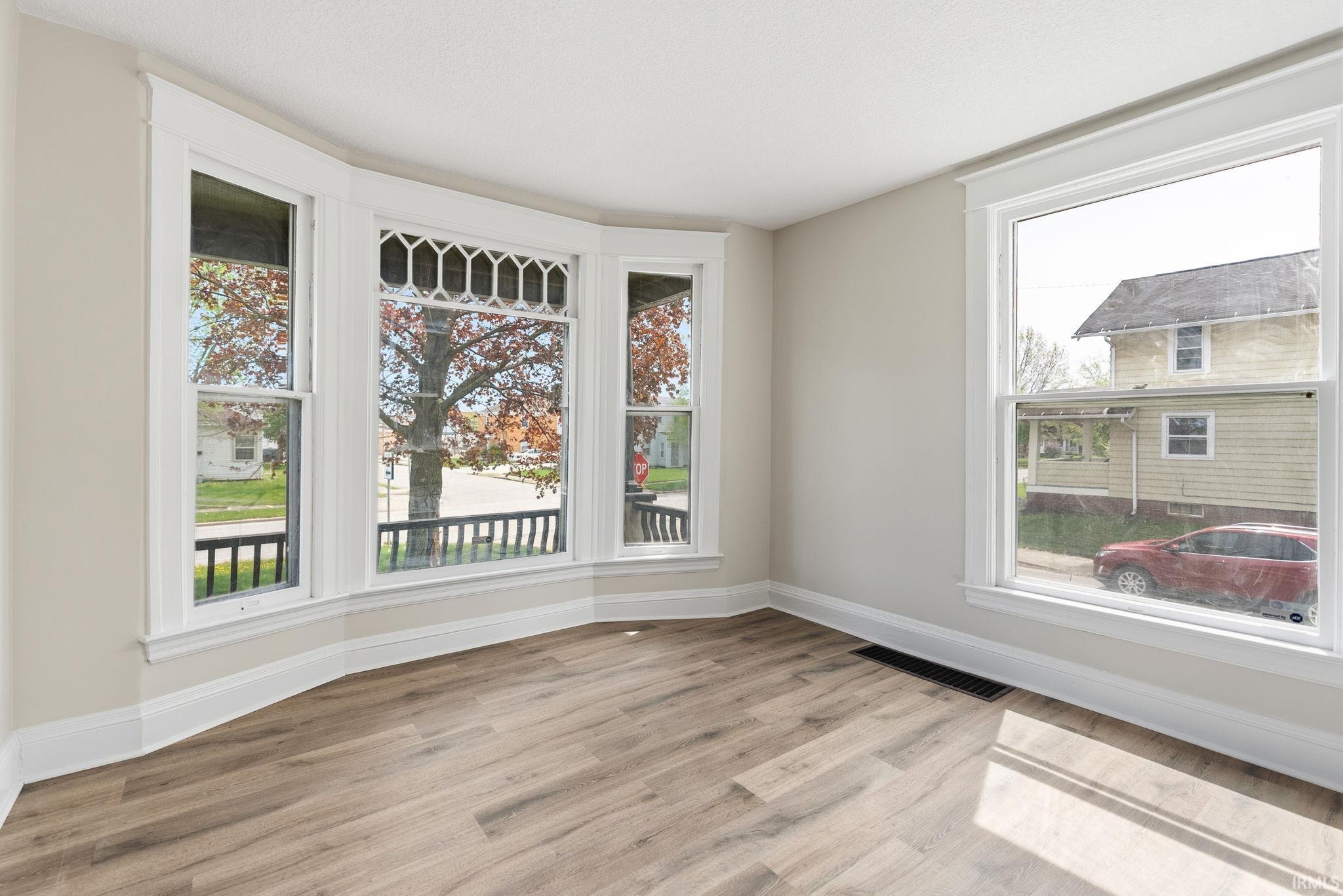 Empty living room with light wood-style flooring and baseboards