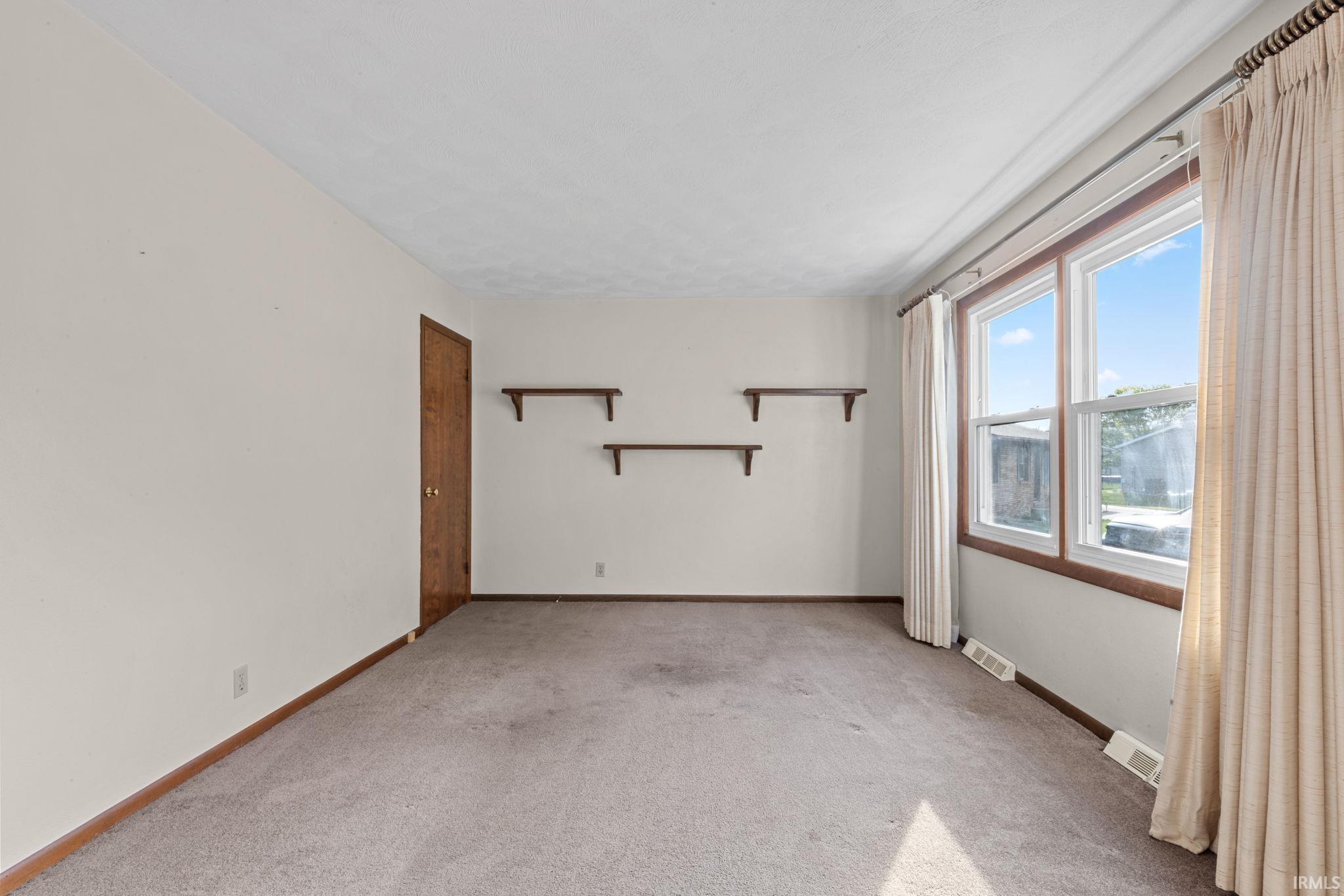 Unfurnished room with light carpet and baseboards