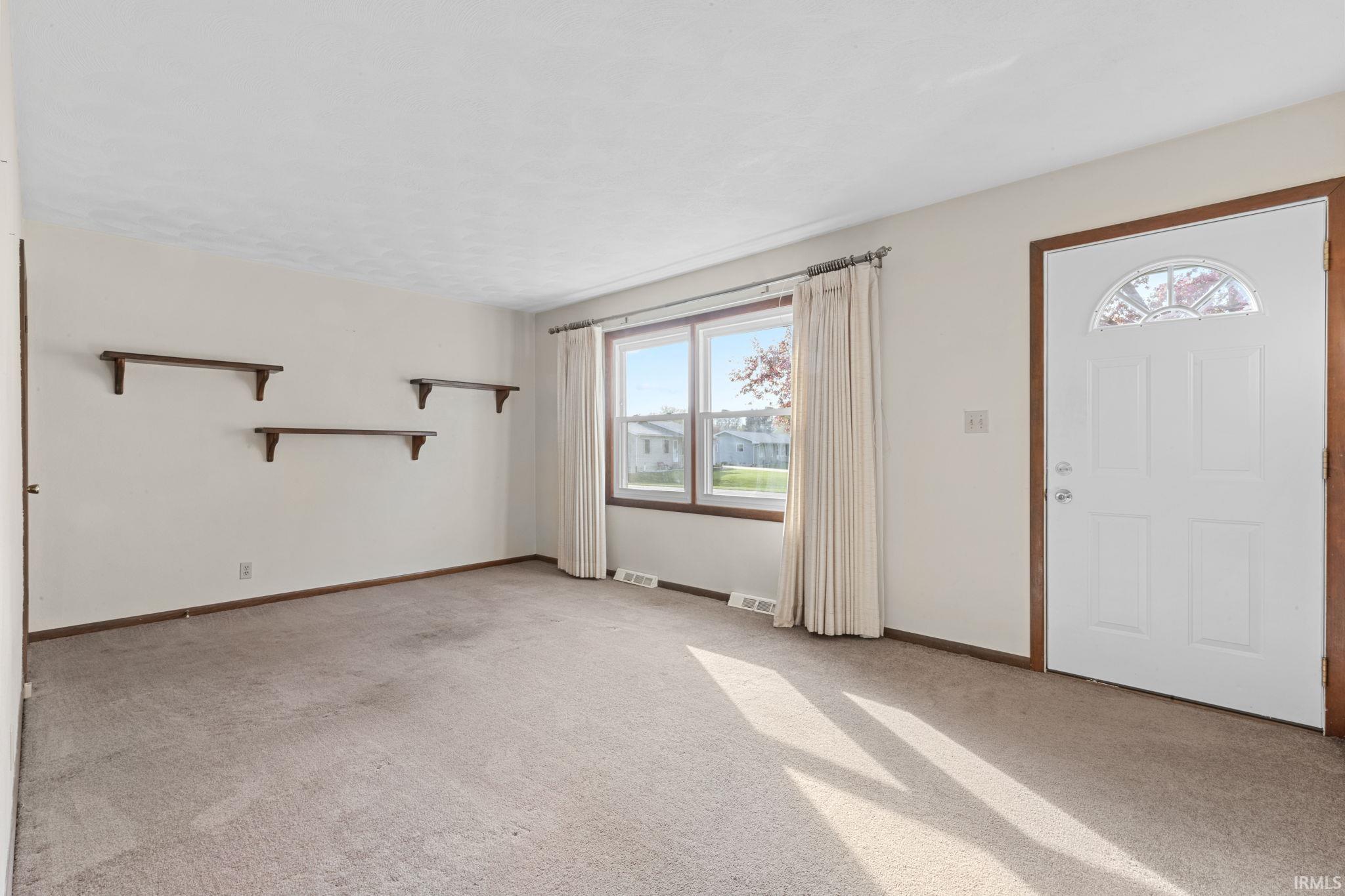 Foyer with light colored carpet