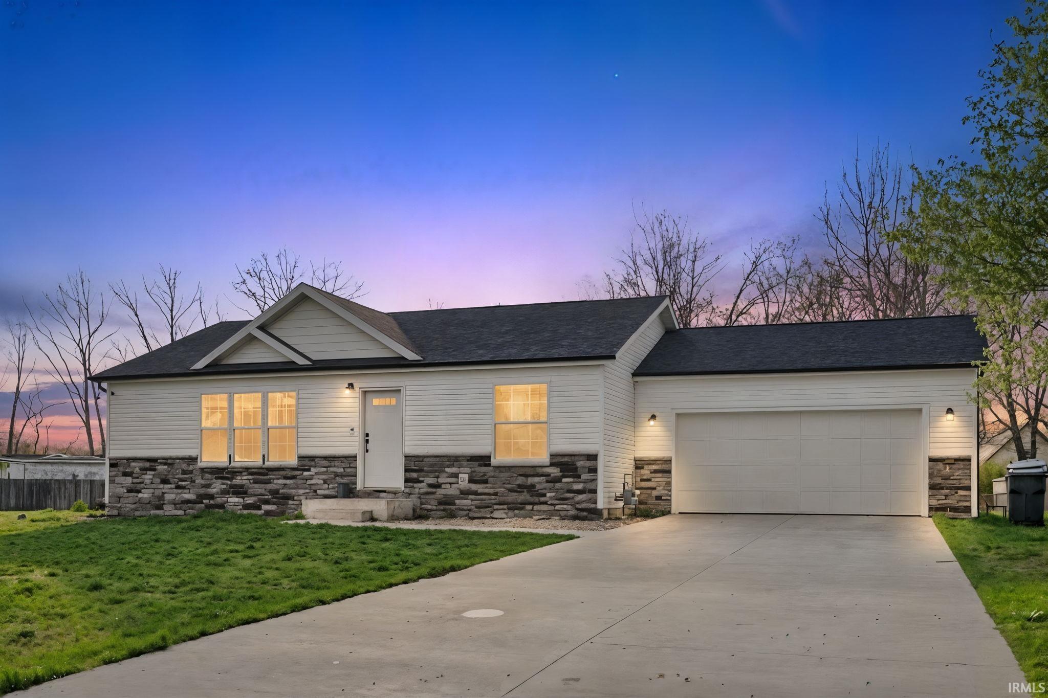 View of front facade with stone siding, concrete driveway, an attached garage, and roof with shingles