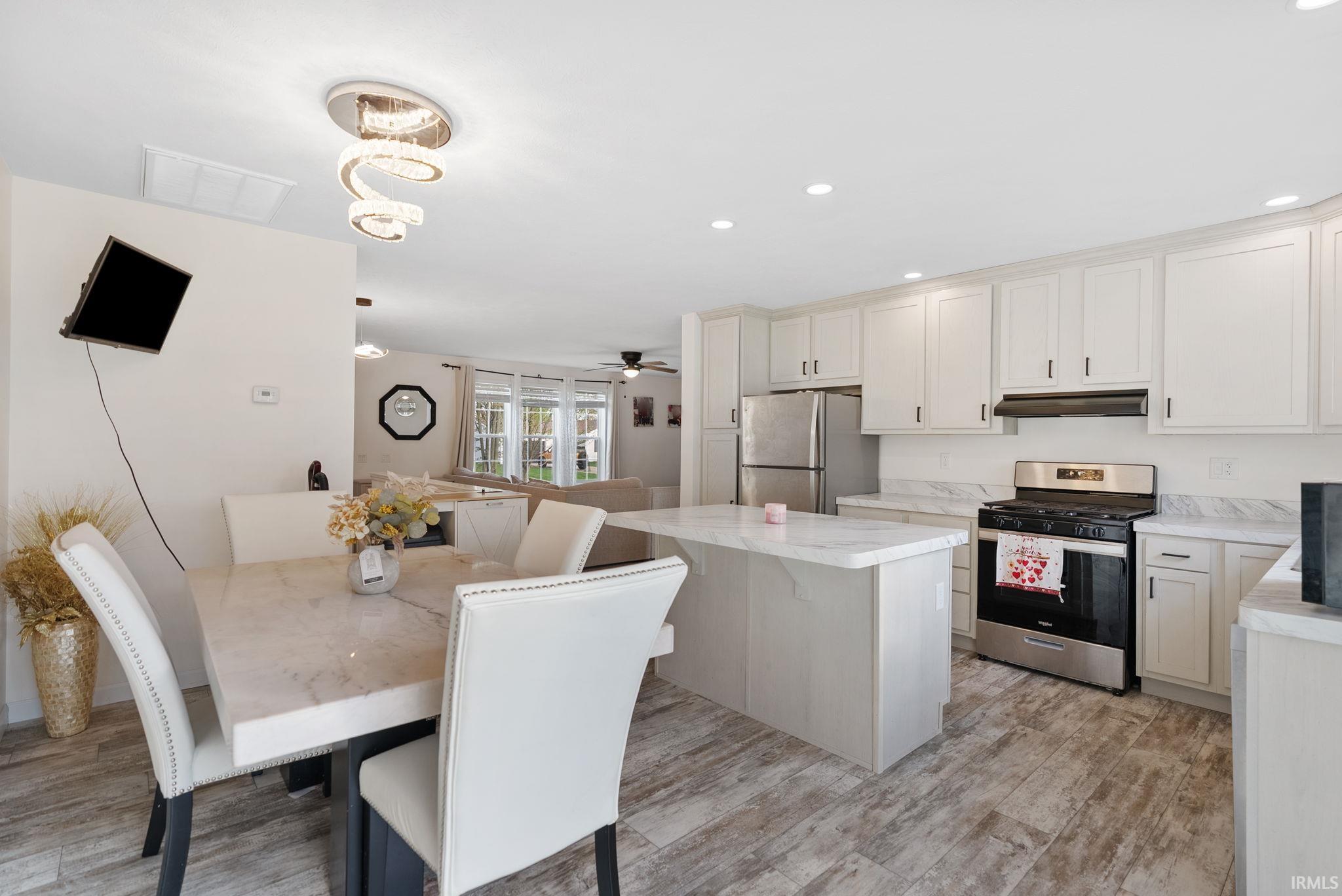 Kitchen featuring stainless steel appliances, light countertops, recessed lighting, a center island, and light wood-style flooring
