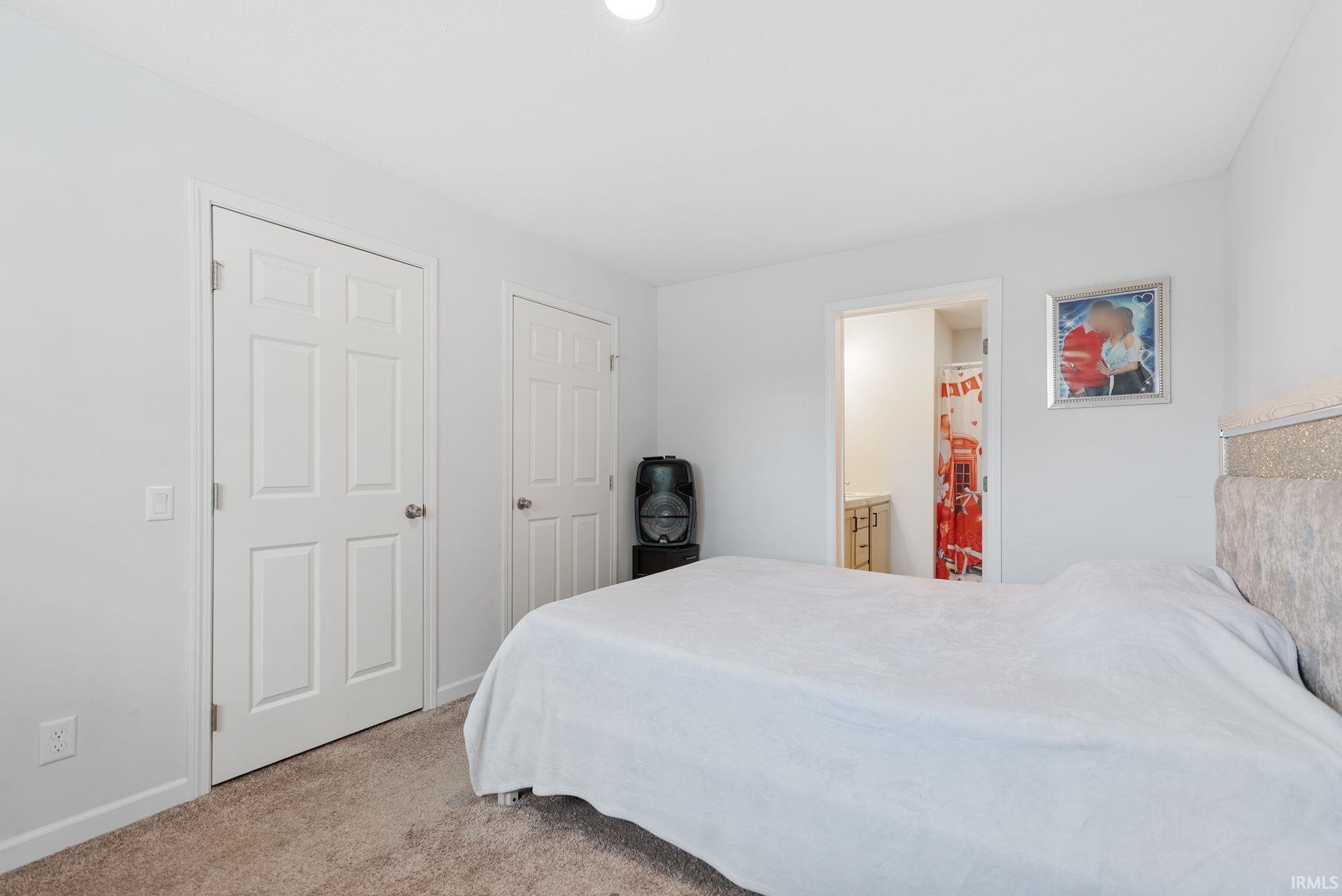 Bedroom with light carpet and baseboards