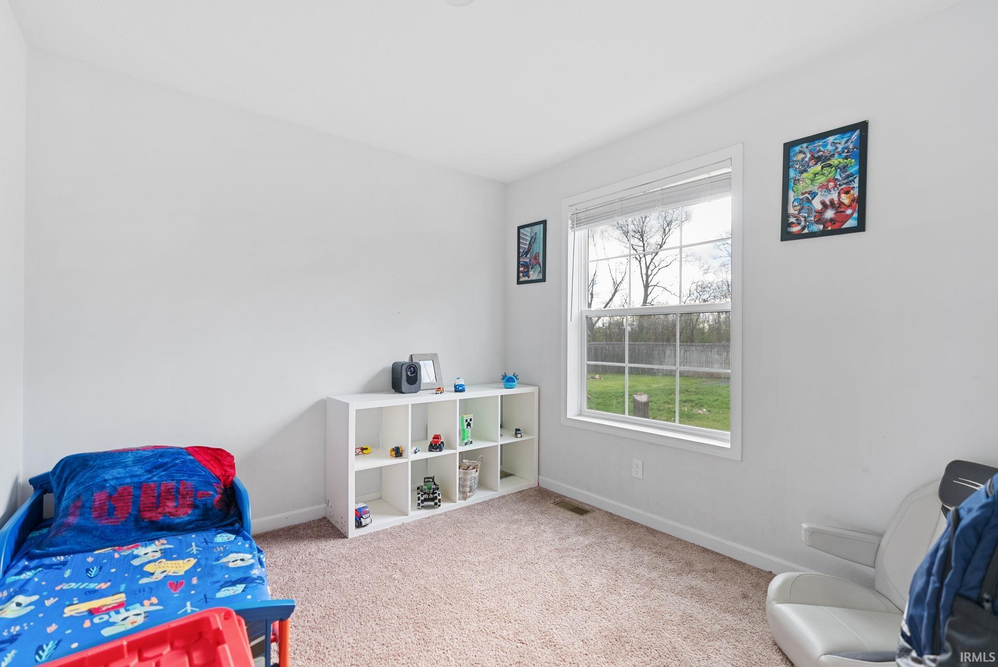Bedroom featuring light colored carpet and baseboards