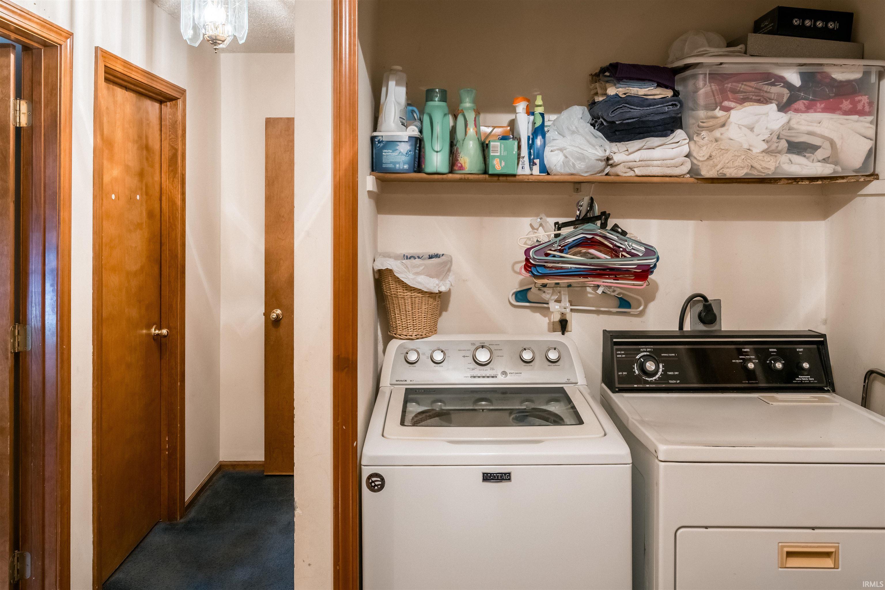 Laundry area featuring separate washer and dryer and dark carpet