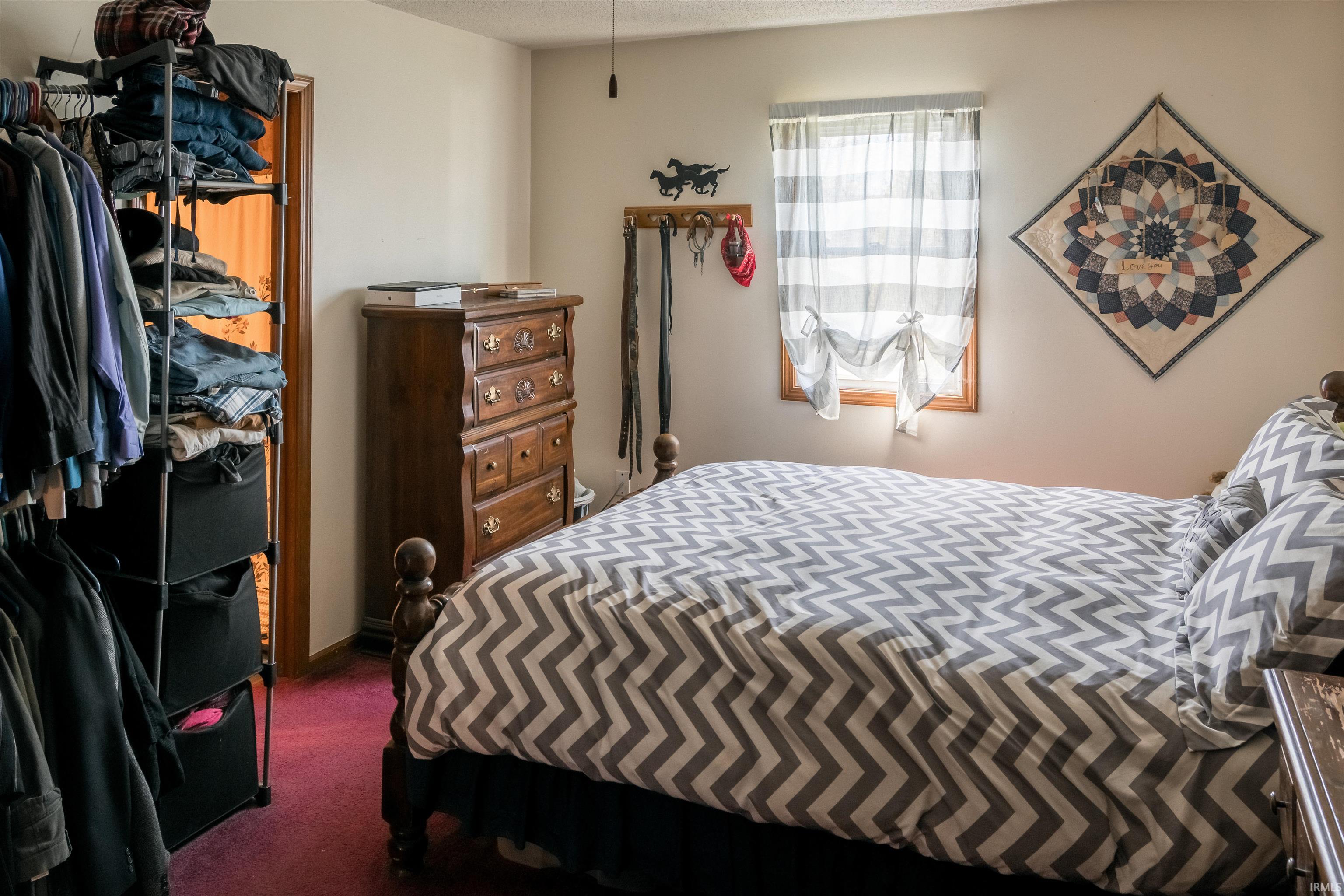 Bedroom with dark colored carpet and a closet