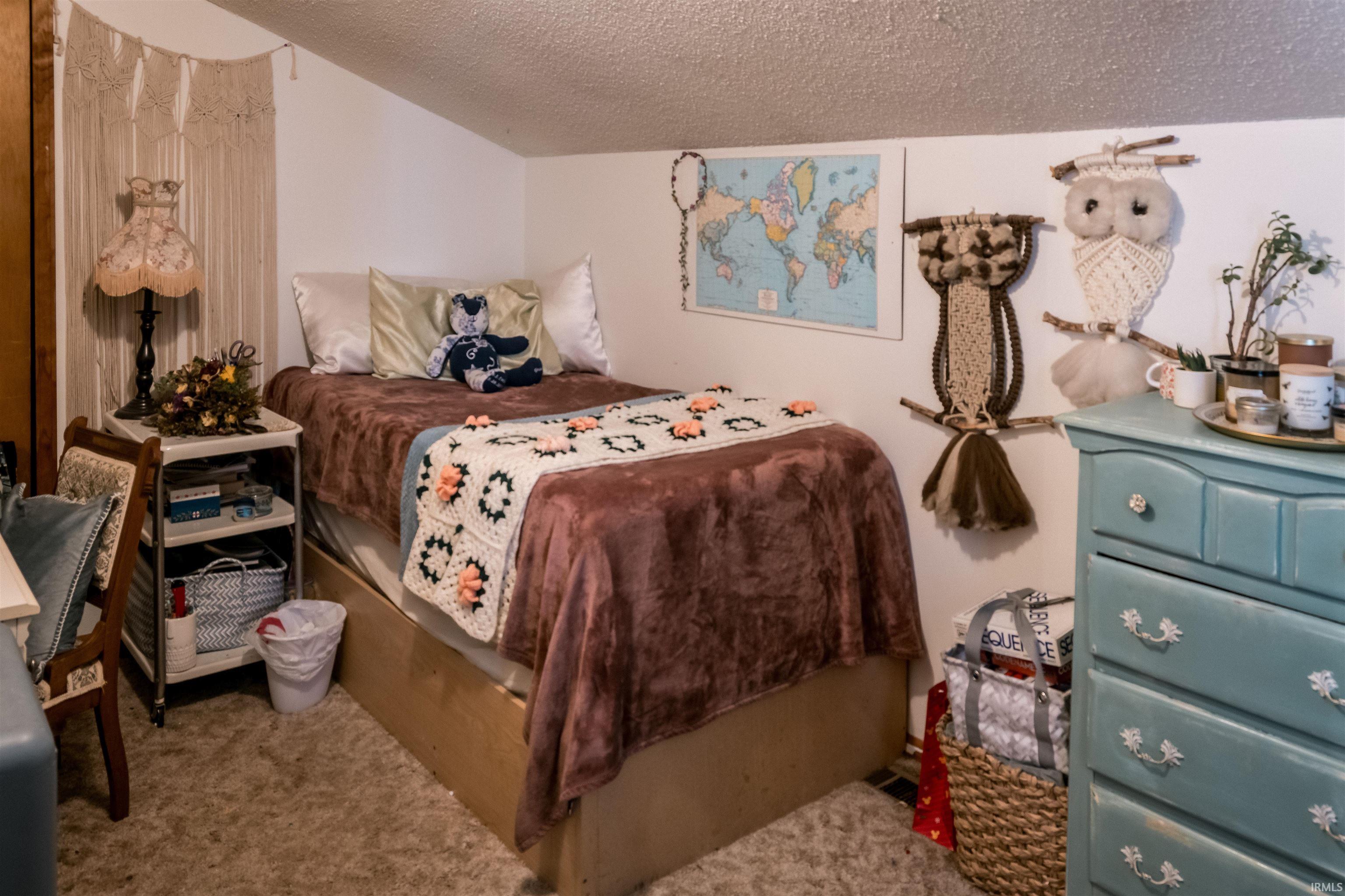 Carpeted bedroom featuring a textured ceiling