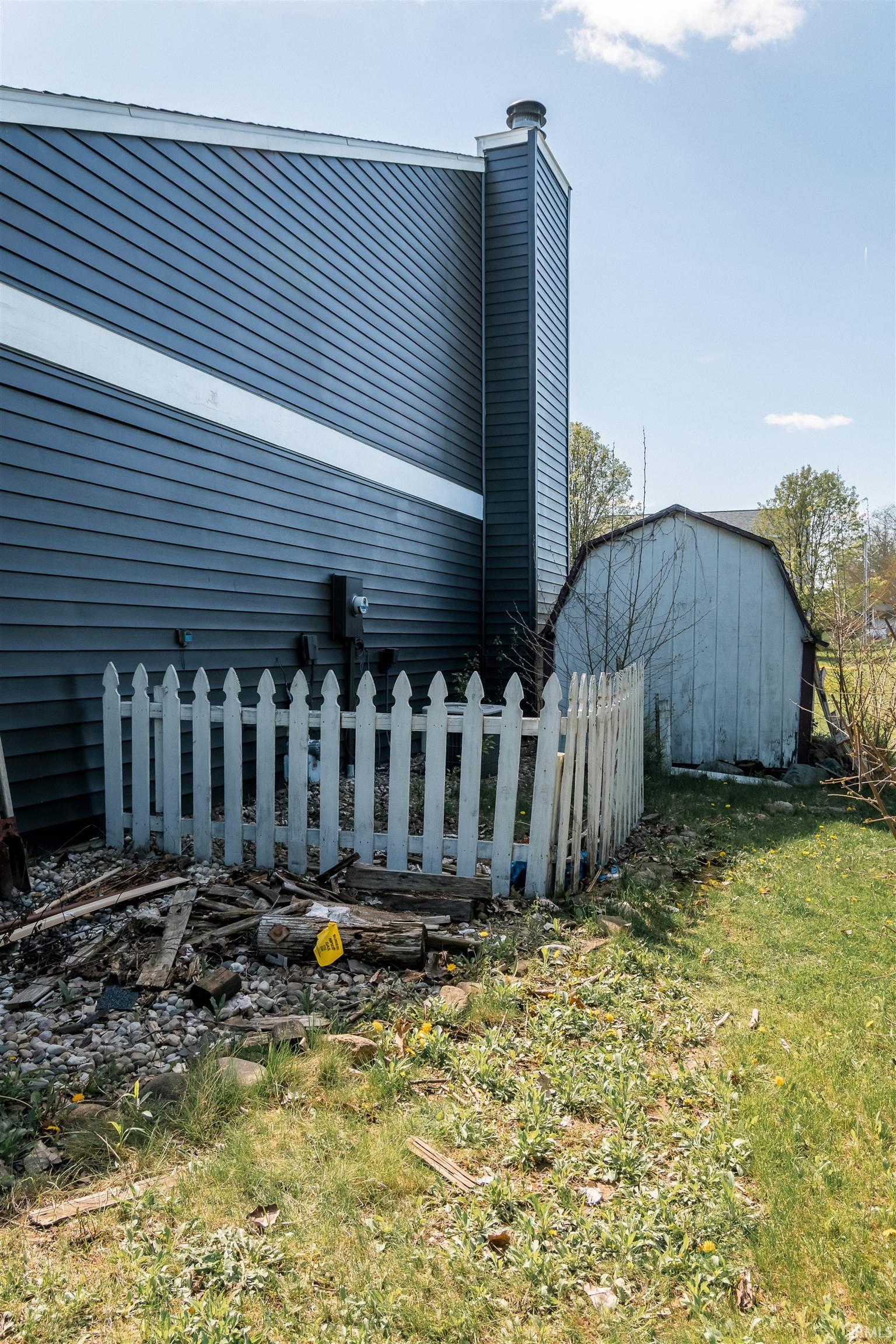 View of side of home with an outdoor structure