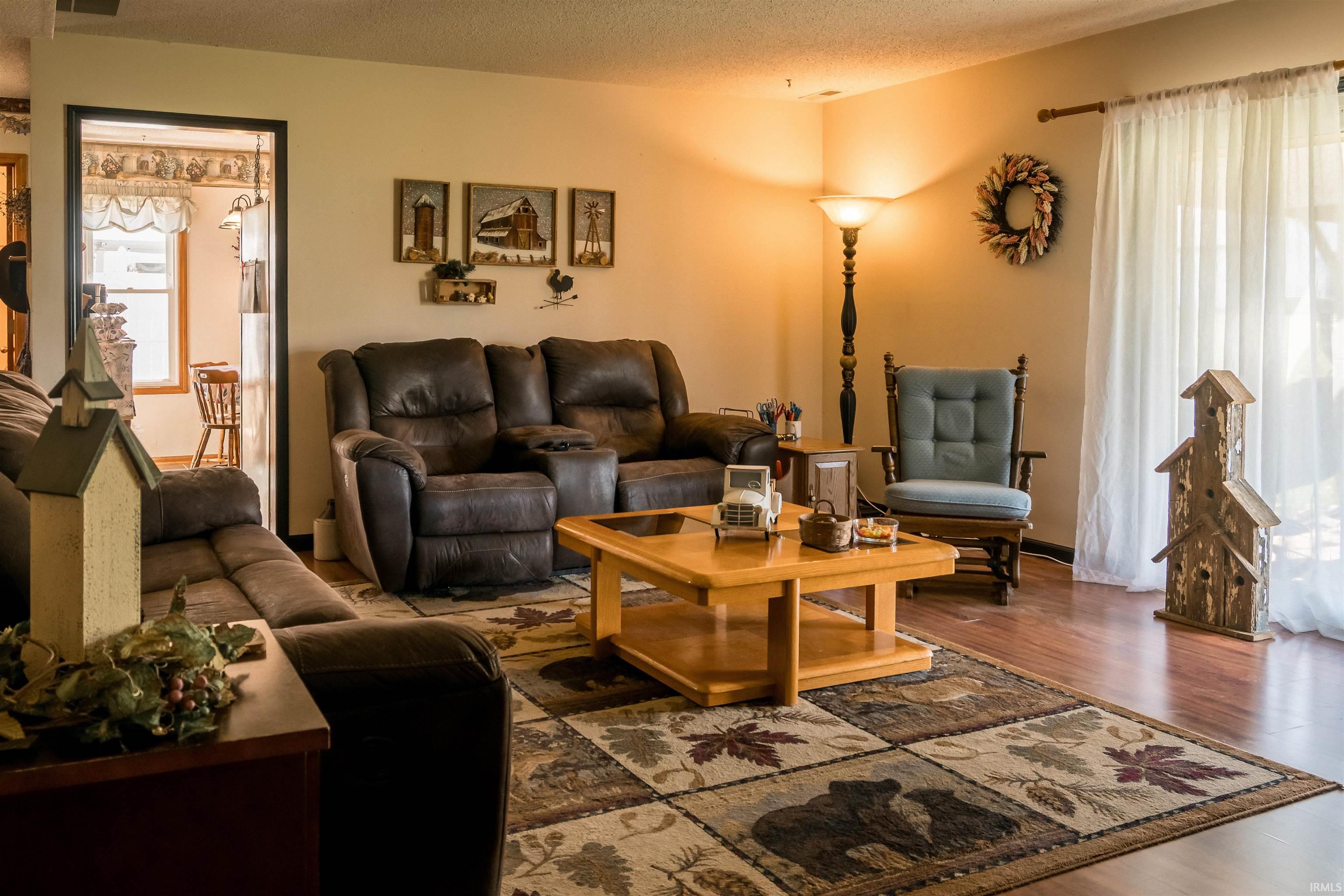 Living area featuring wood finished floors and a textured ceiling