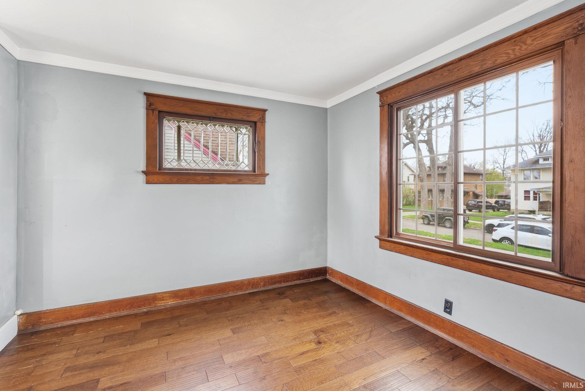 Unfurnished room with wood-type flooring and ornamental molding
